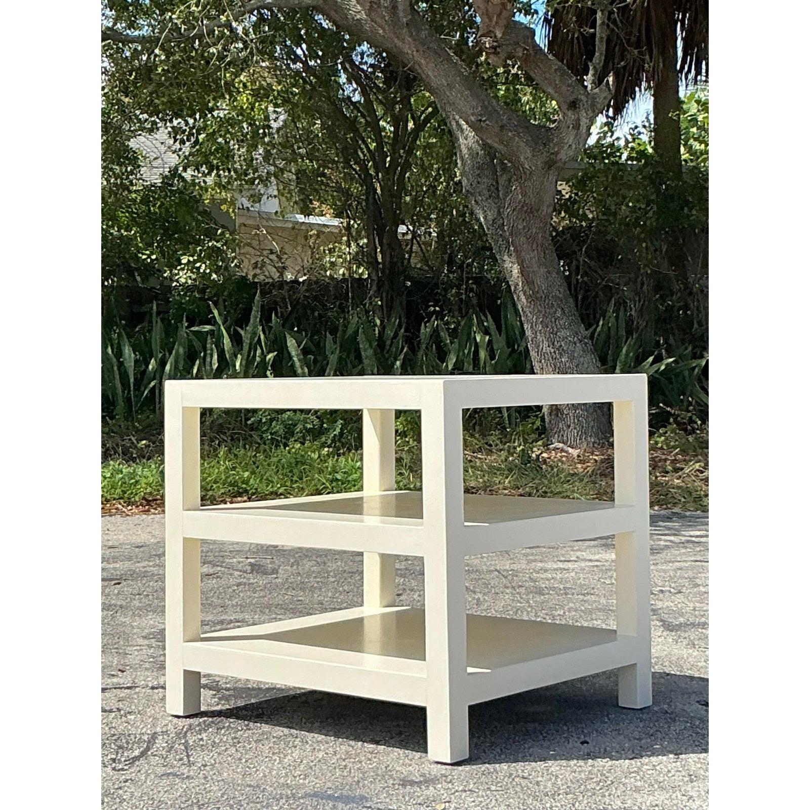 This elegant vintage Regency side table features a sophisticated stacked design, finished in a creamy lacquered coating that enhances its timeless appeal. With its clean lines and versatile silhouette, this piece effortlessly blends into a variety