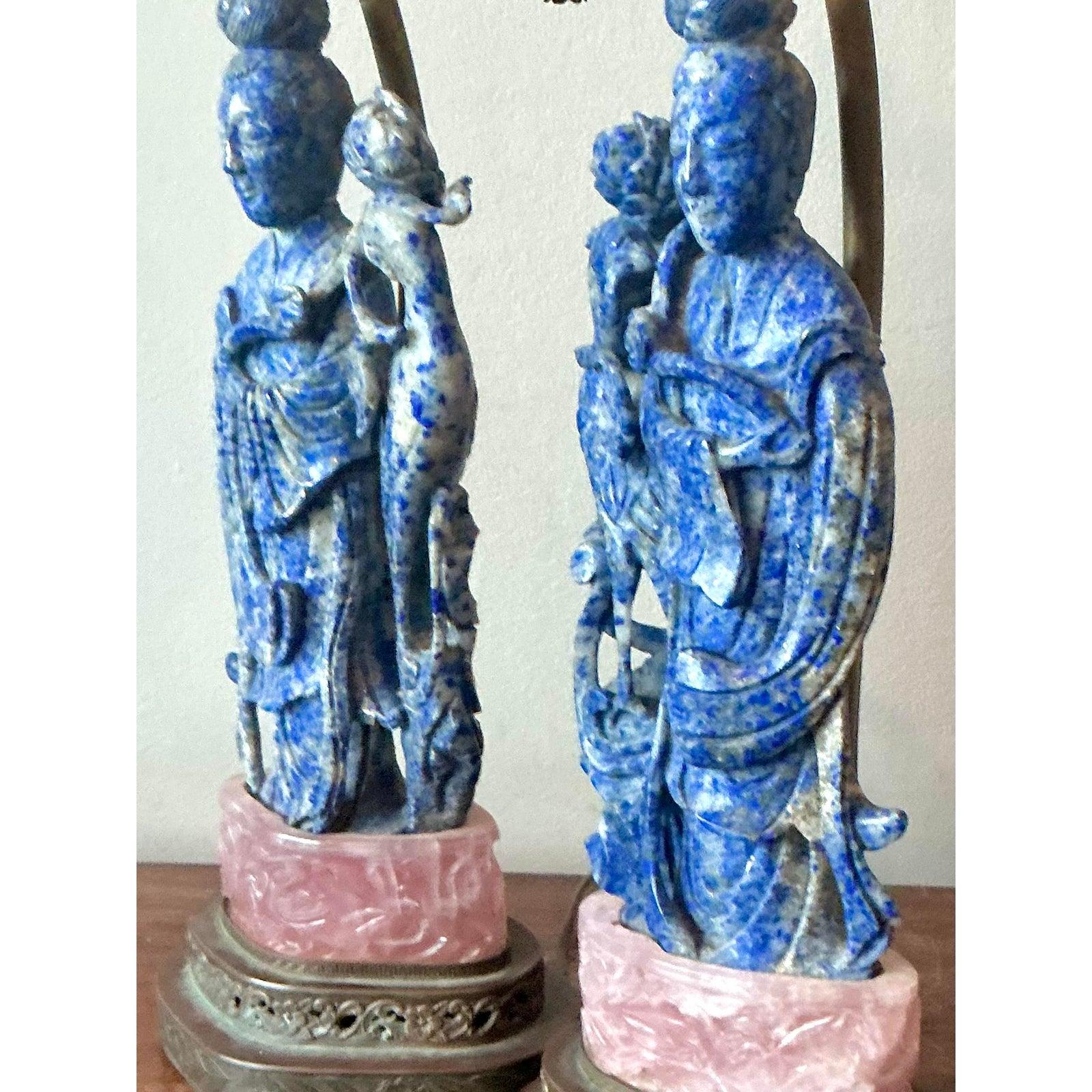 Wir präsentieren ein wahrhaft prächtiges Paar Vintage-Lampen, die den opulenten Charme des Hollywood-Regency-Designs verströmen. Jede Lampe hat einen auffälligen, aus echtem Lapislazuli geschnitzten Figurenkörper, der seinen fesselnden tiefblauen