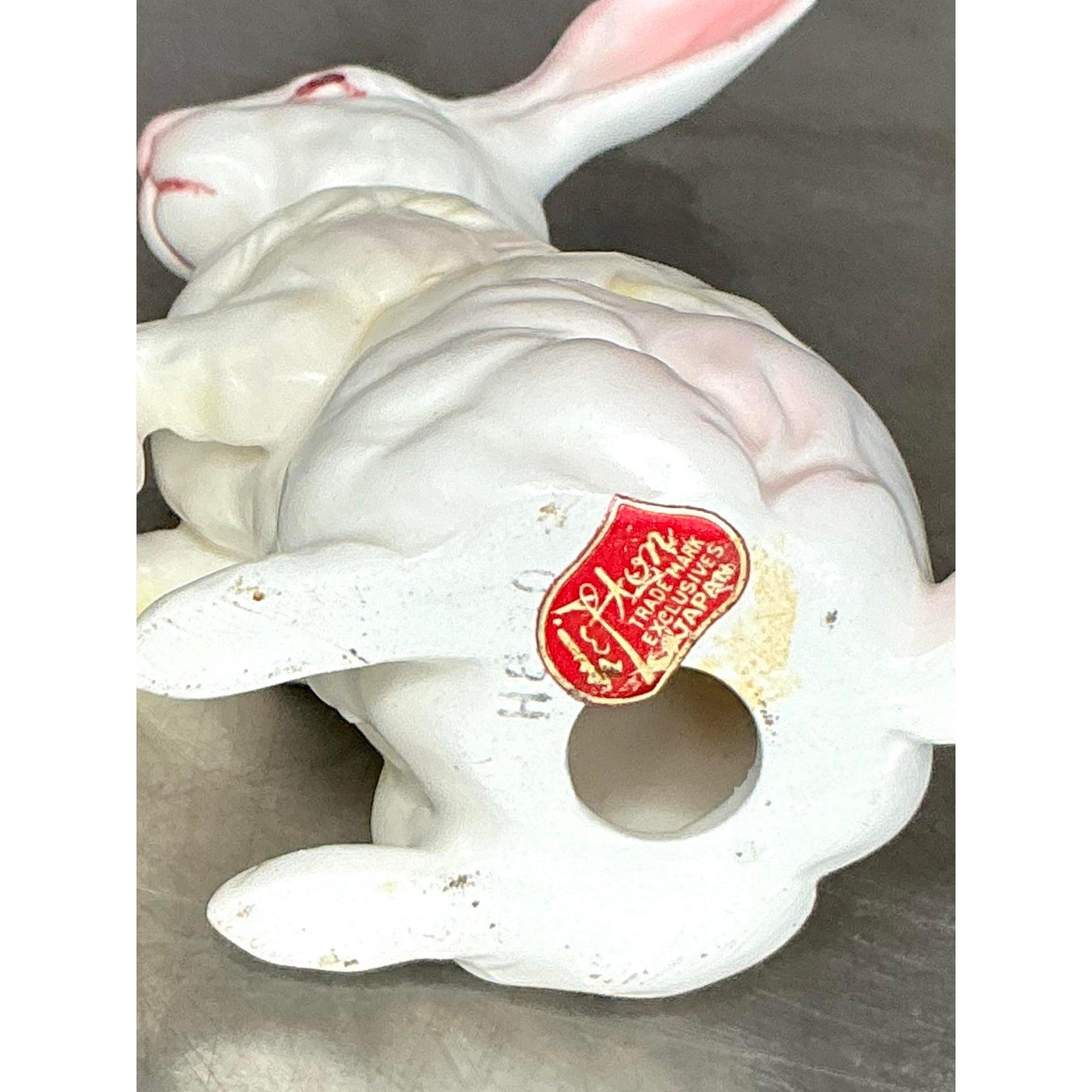 Dai un tocco di estrosità e fascino vintage alla tua casa con questo squisito set di sei statuette di coniglio in porcellana dipinte a mano. Realizzati in Giappone, questi delicati coniglietti bianchi sono caratterizzati da occhi rosa, pellicce