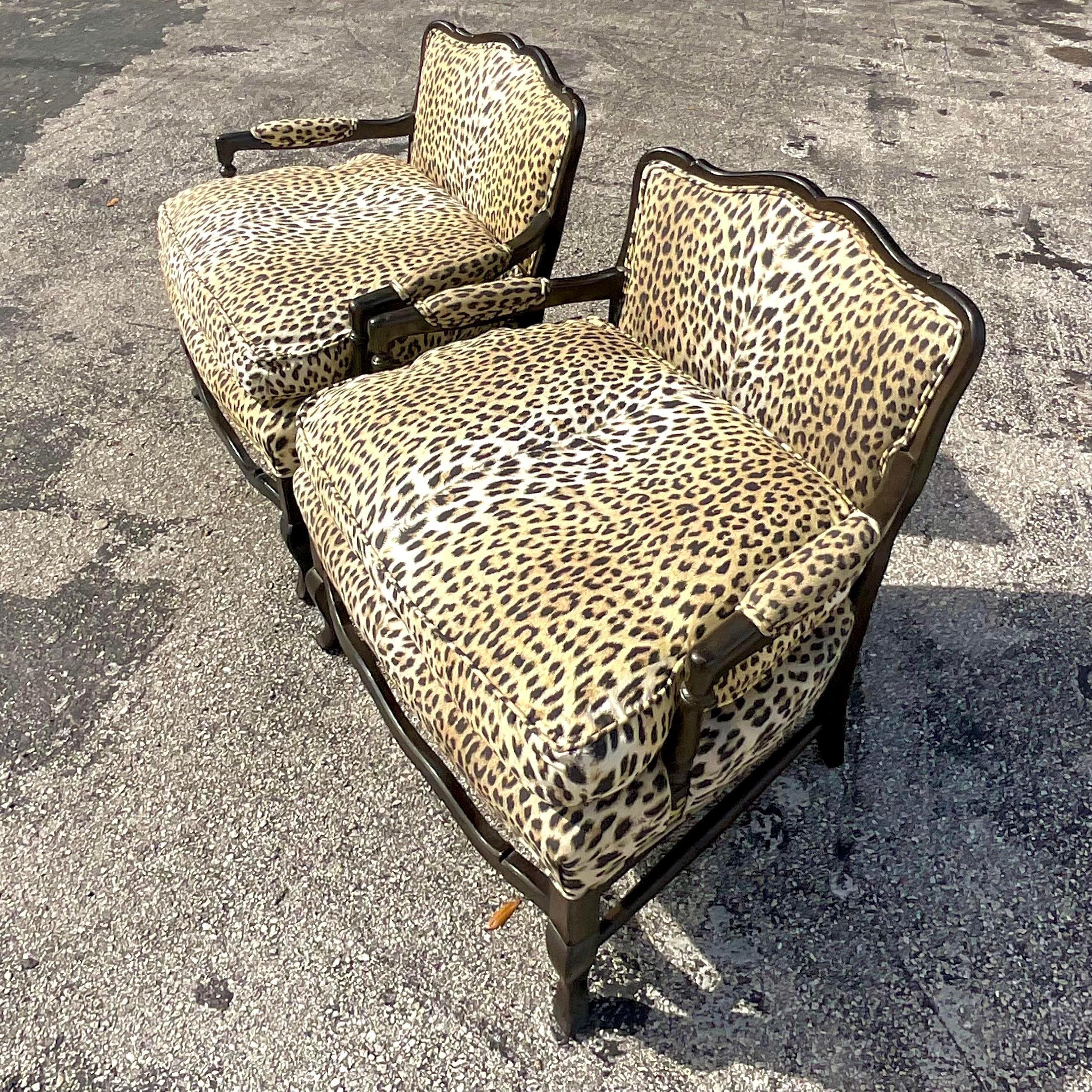 A fantastic pair of vintage Regency Bergere chairs. A chic printed leopard on thick down upholstery. A classic retro shape with a lower back panel for glamour. Acquired from a Palm Beach estate. 