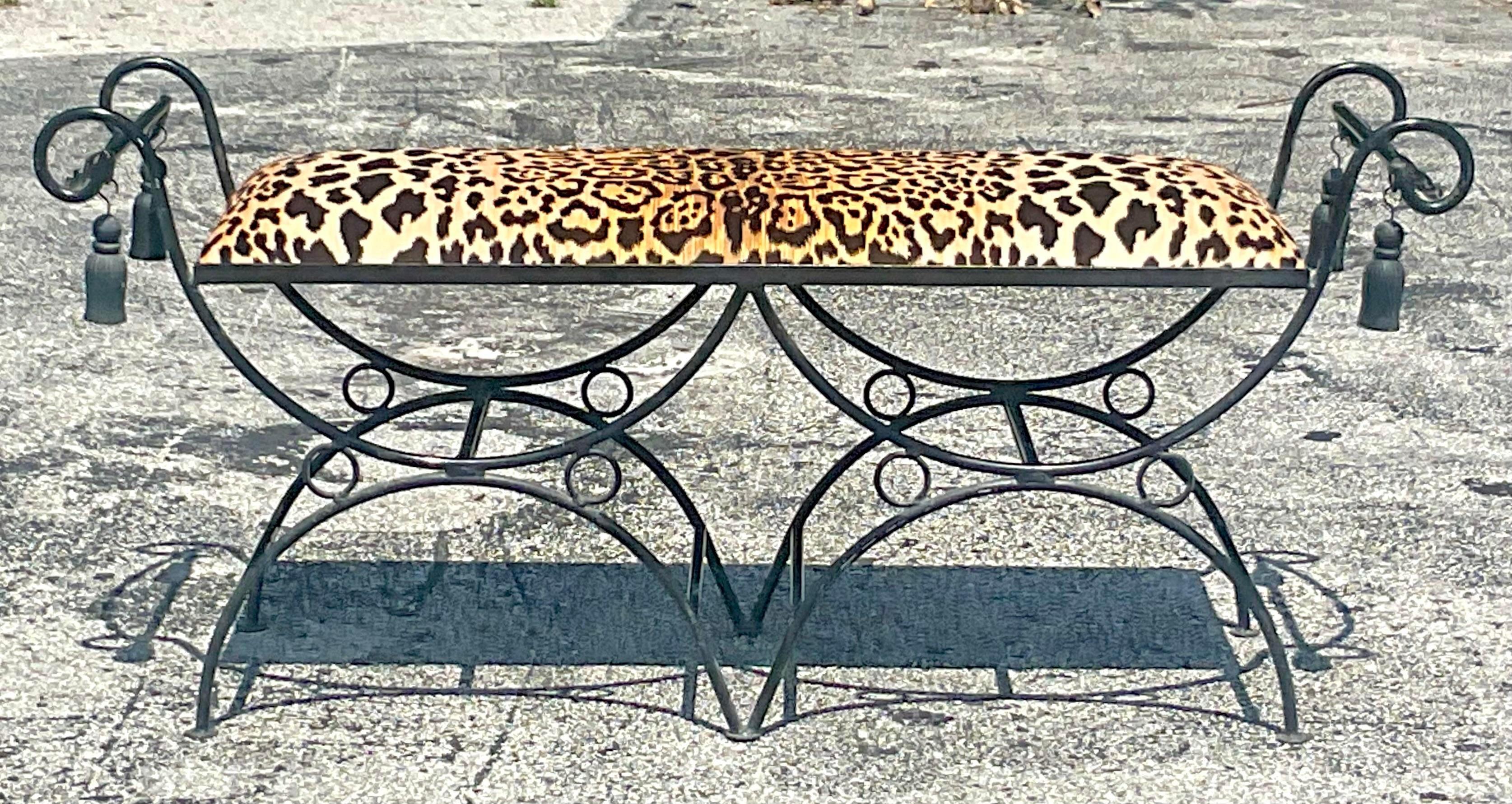 A fabulous vintage Regency wrought iron bench. Beautiful swirl detail with heavy hanging tassels. A newly upholstered leopard velvet seat. Acquired from a Palm Beach estate.