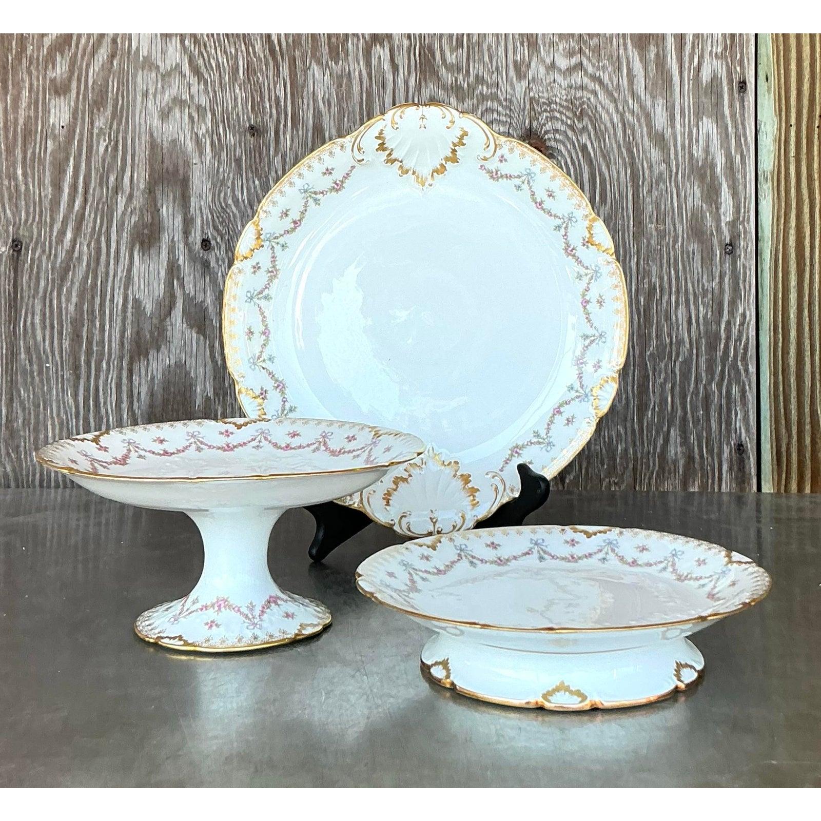 Este exquisito juego de porcelana Limoges de 30 piezas muestra la elegancia atemporal de la época de la Regencia con sus delicados motivos florales, sus intrincados adornos dorados y sus bordes festoneados. La fina artesanía de porcelana se hace