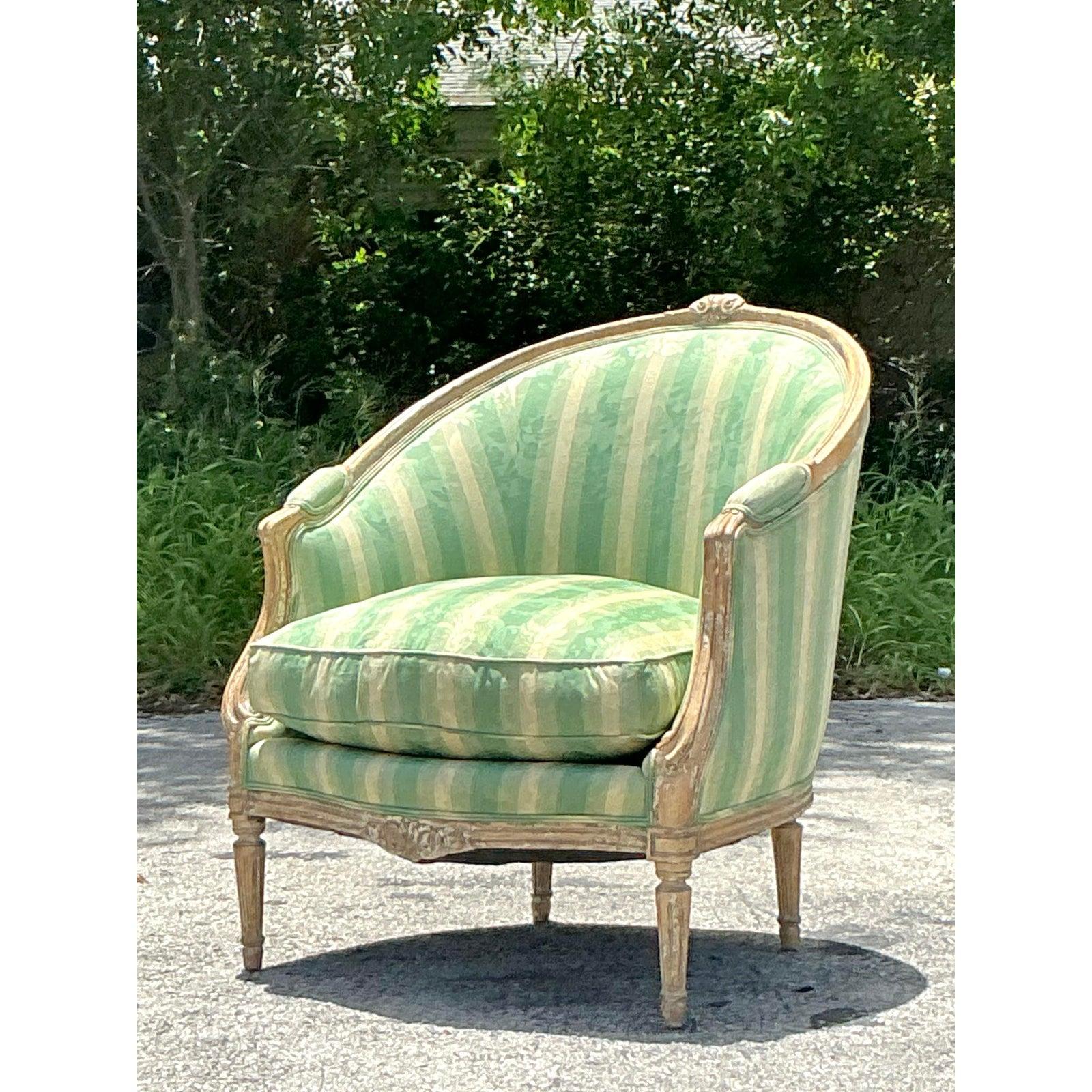 D'une élégance française intemporelle, cette étonnante Bergère vintage de style Louis XVI est un chef-d'œuvre de design classique. Son dossier en tonneau gracieusement incurvé et ses accoudoirs fermés créent une silhouette accueillante et