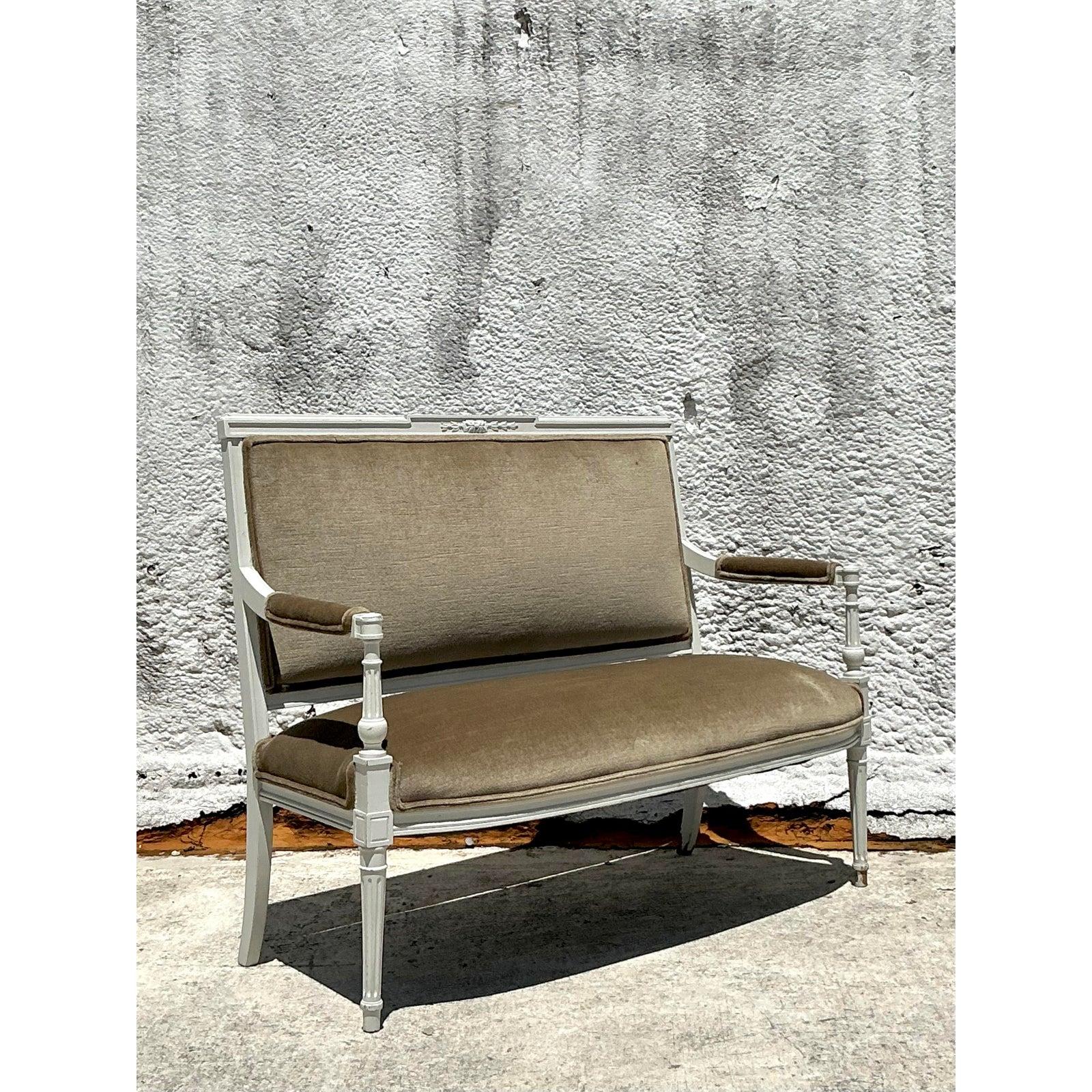 Grace your home with the timeless elegance of this exquisite Vintage Louis XVI Style Settee, a captivating piece that effortlessly blends historical charm with refined sophistication. This charming loveseat features the signature Neoclassical