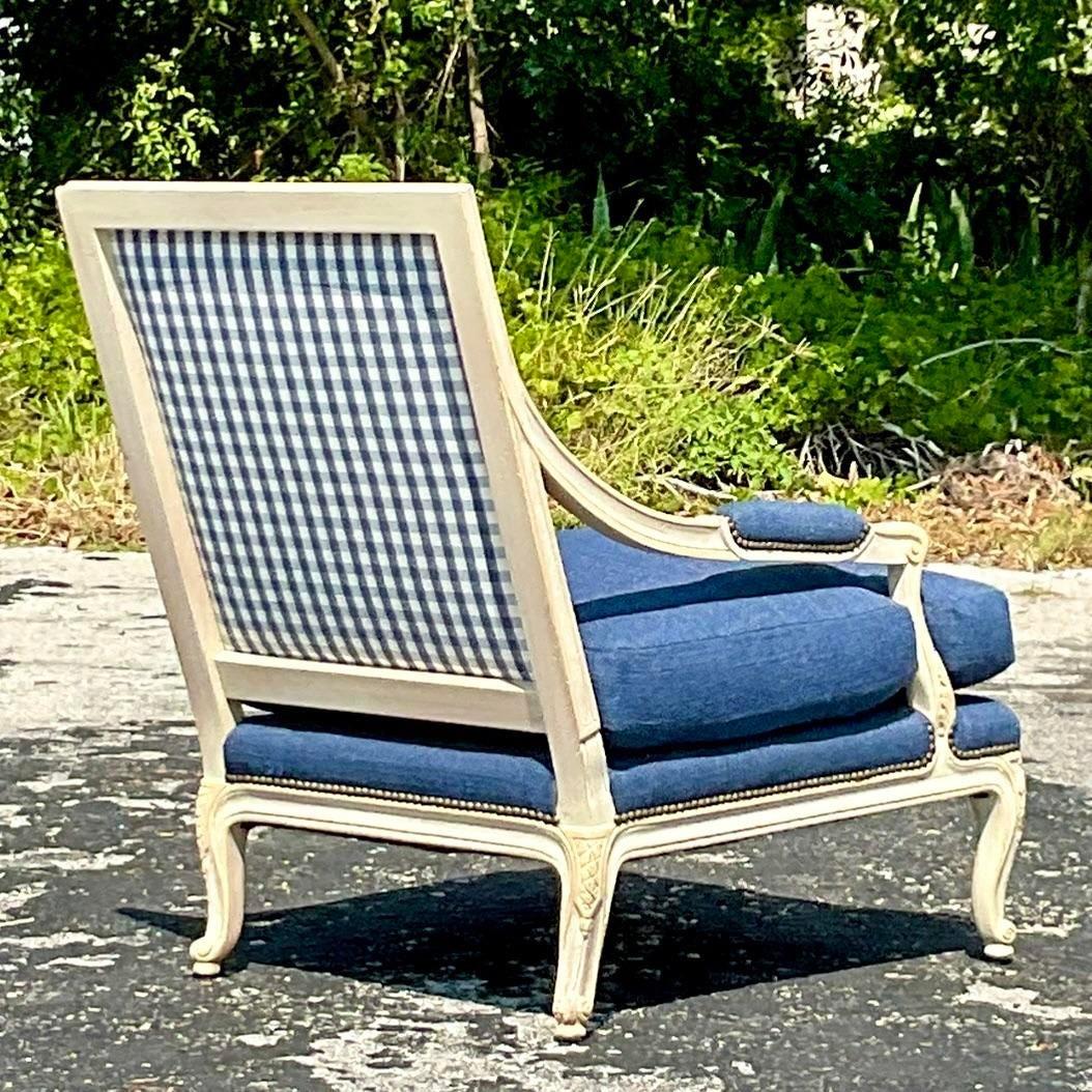 Ein fabelhafter Vintage Regency Bergere Stuhl. Ein schöner Louis XVI-Stil mit gewebter indigoblauer Baumwolle. Kontrastierende, karierte Rückenpolsterung und schicke Nagelkopfverzierung. Erworben aus einem Nachlass in Palm Beach.