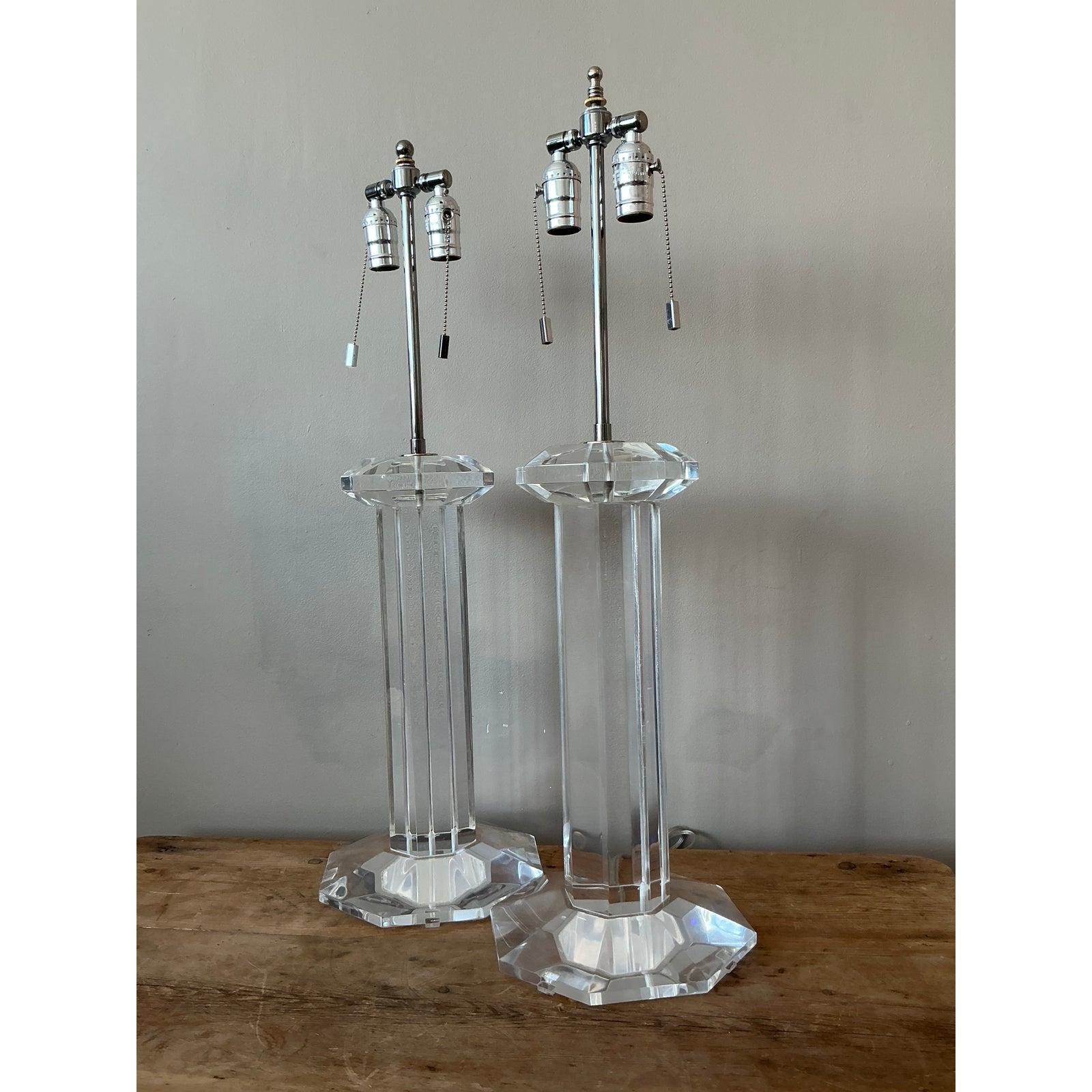 Elevate your interior with this striking pair of vintage Hollywood Regency Lucite column lamps. These elegant lamps exude a timeless sophistication, featuring a multifaceted hexagonal design crafted from clear Lucite. The sleek, architectural form