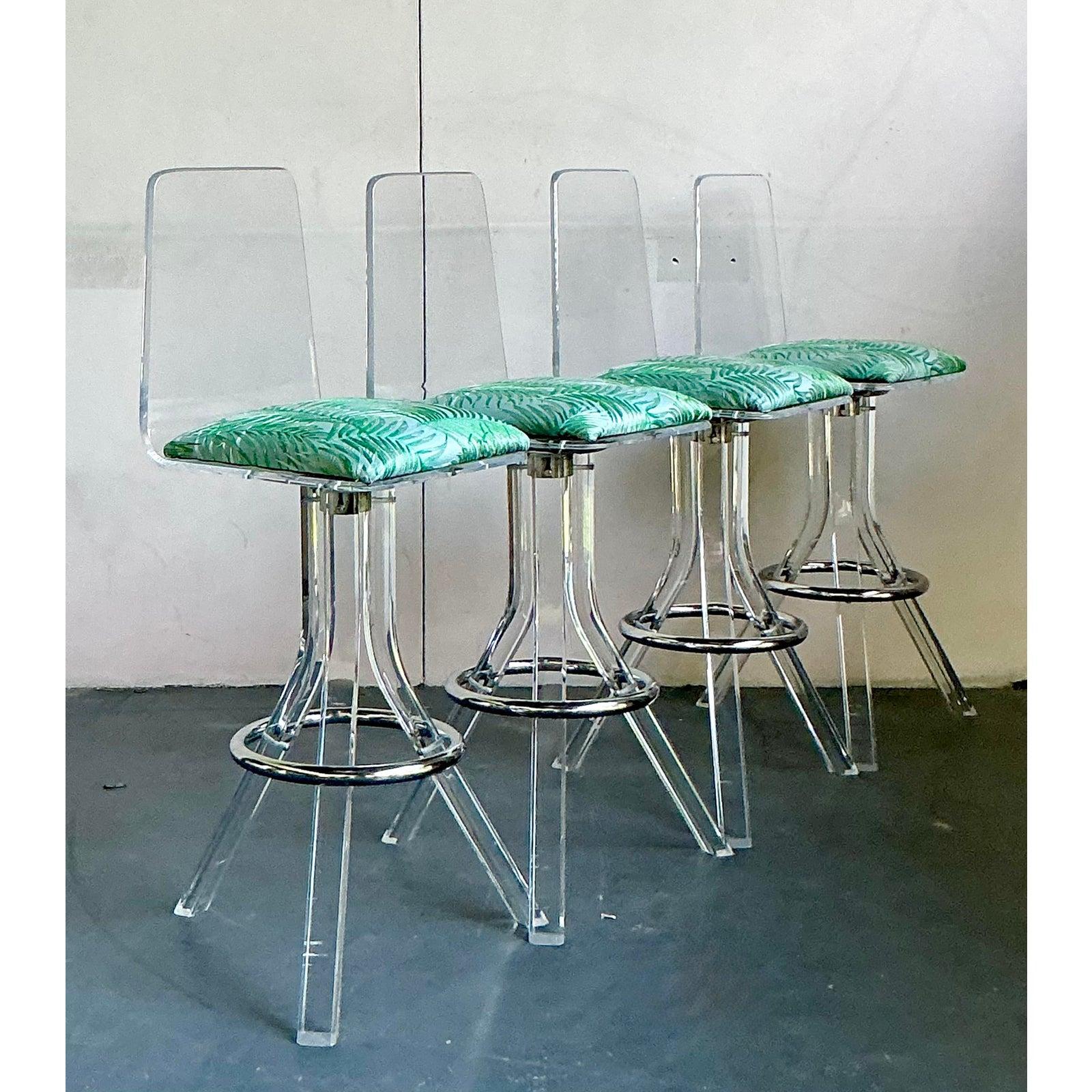 Elevate your home bar or kitchen island with this fabulous set of four vintage swivel bar stools. Embodying the glamorous spirit of the Hollywood Regency and Mid-Century Modern eras, each stool features a gracefully molded, transparent lucite frame.