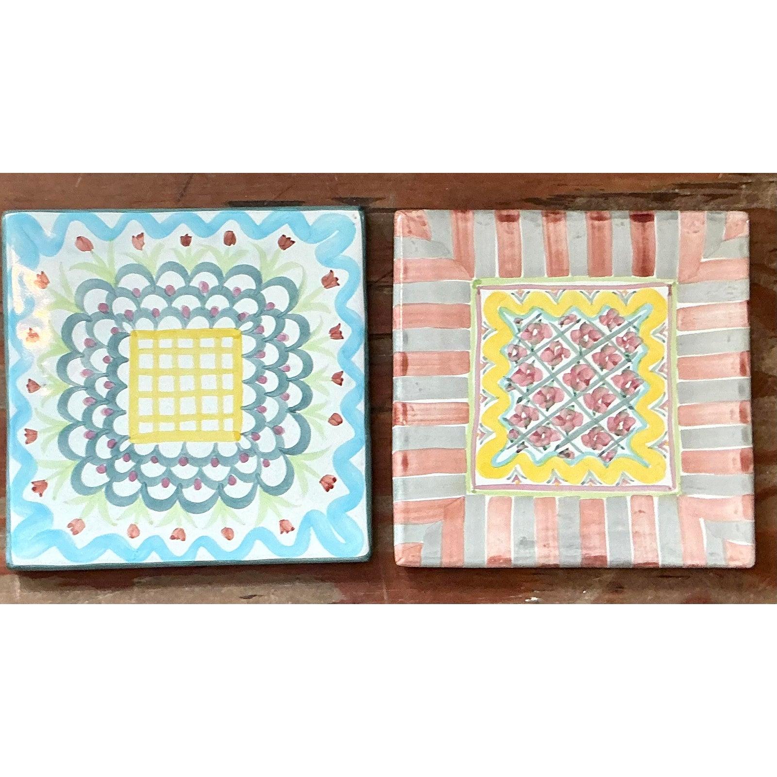 Cet ensemble de deux dessous de plat en céramique vintage de MacKenzie-Childs insuffle à votre table le charme fantaisiste et l'héritage artisanal. Ces carreaux peints à la main reprennent l'esthétique des livres de contes de la marque avec un