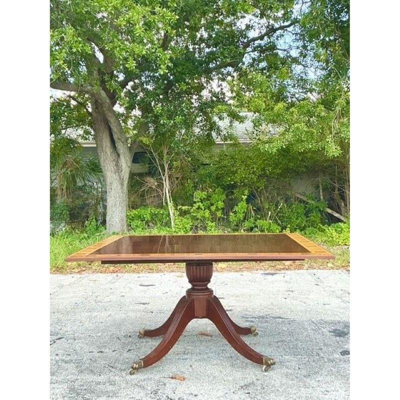 Discover timeless elegance with this magnificent Vintage Regency Mahogany and Birdseye Duncan Phyfe Square Dining Table. A truly impressive statement piece, this table features a lustrous mahogany top exquisitely bordered by a contrasting birdseye
