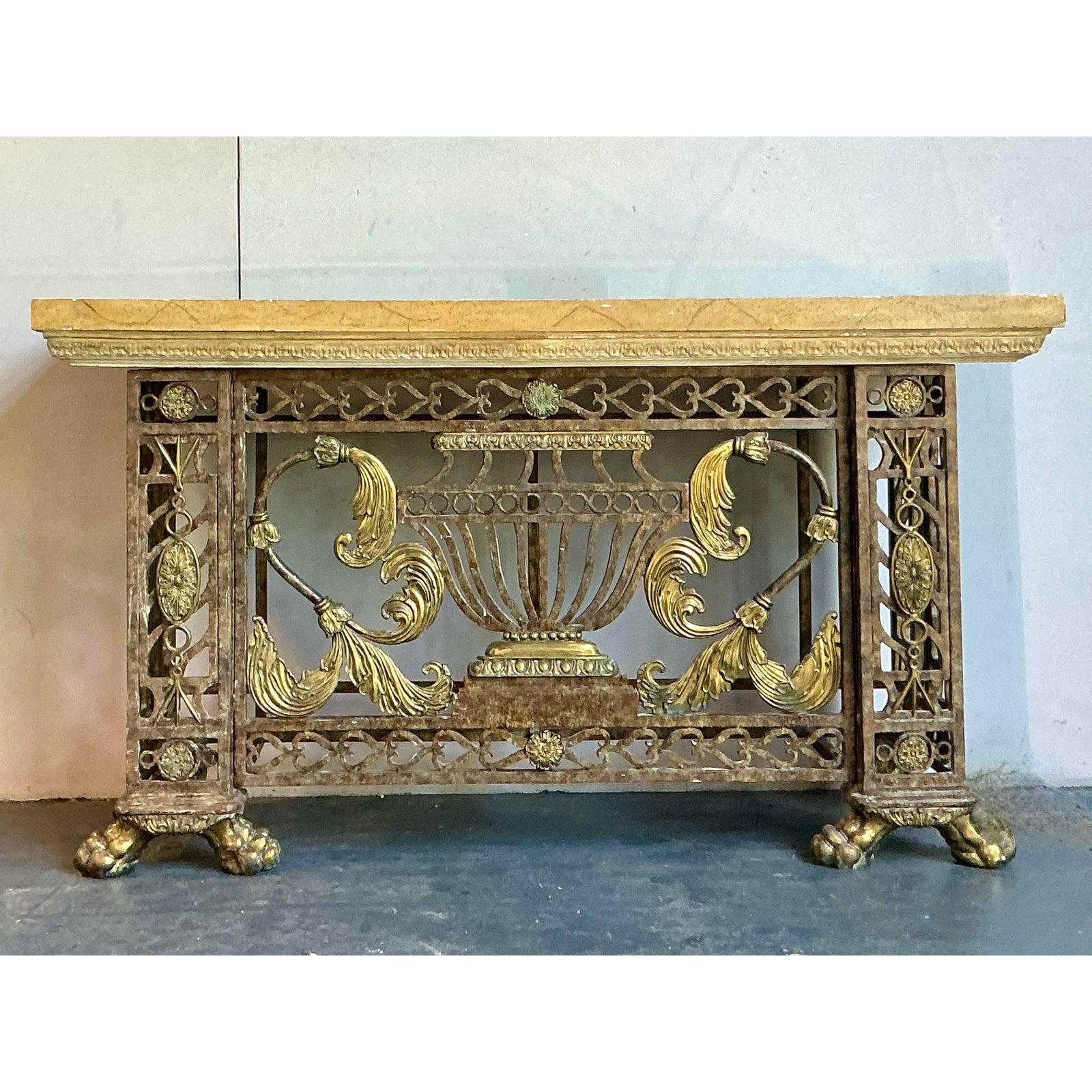 Scopri l'impareggiabile maestria di Maitland Smith con questa magnifica consolle in stile neoclassico. Vero e proprio capolavoro di design e artigianato, questo pezzo presenta una base in ghisa dai dettagli intricati con una finitura ricca e