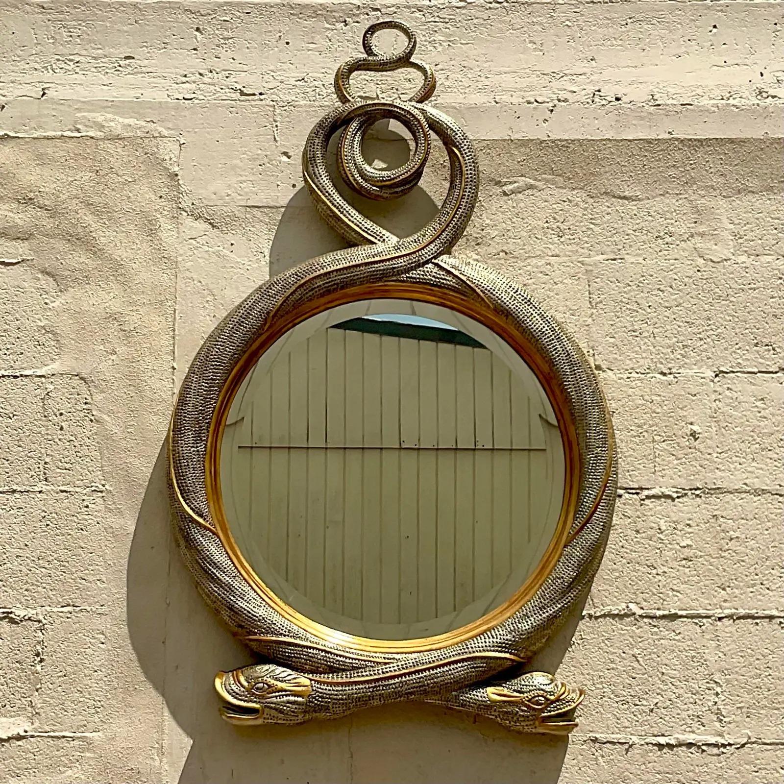 Fantastic vintage Regency mirror. A stunning Maitland Smith mirror with a twisted Serpent design. A chic gilt finish in silver and gold. Incredible attention to detail. Acquired from a Palm Beach estate.