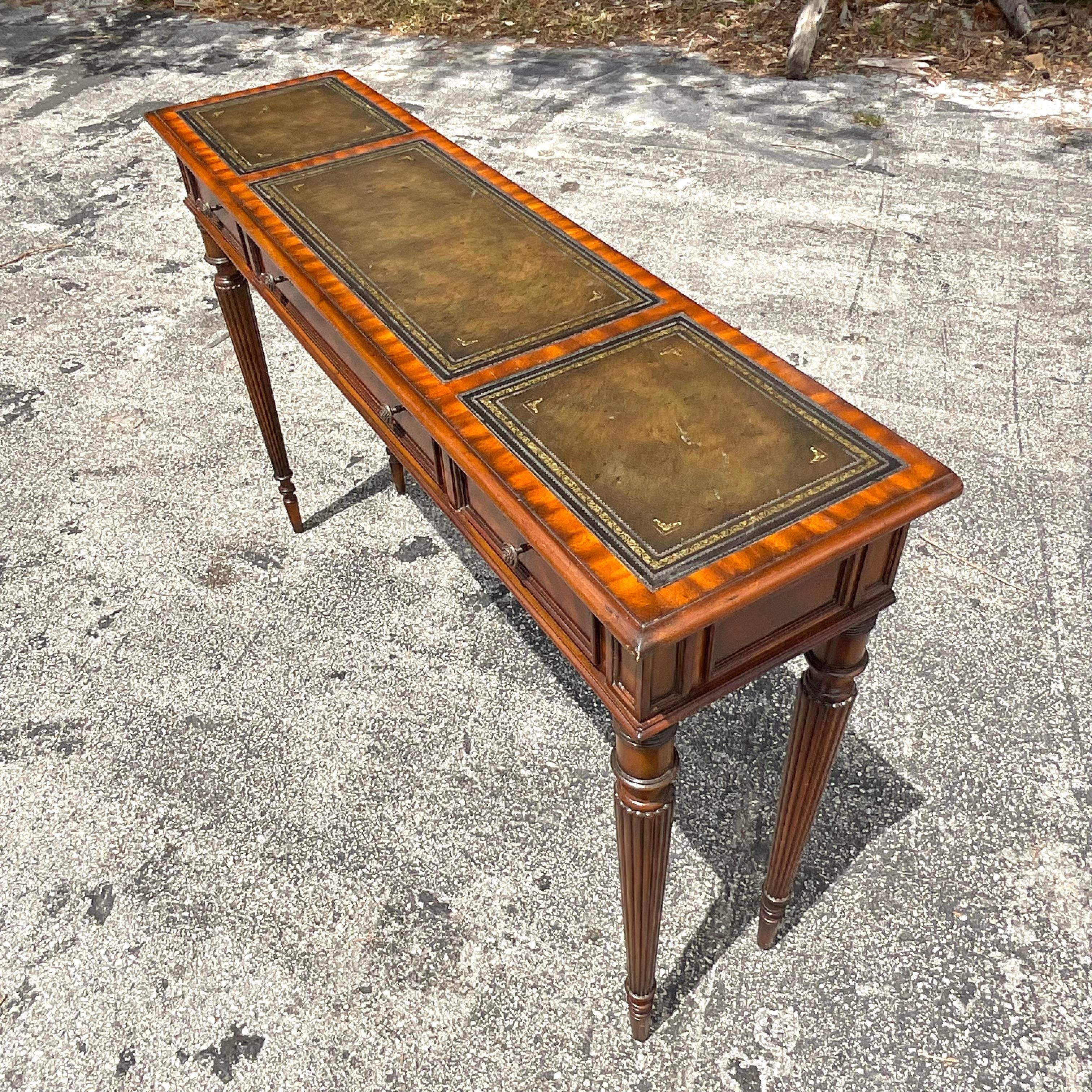Werten Sie Ihren Eingangsbereich mit dem Vintage Regency Maitland Smith Konsolentisch mit Lederprägung auf, ein Zeugnis amerikanischer Raffinesse. Die mit viel Liebe zum Detail gefertigte Oberfläche aus geprägtem Leder strahlt zeitlosen Charme aus