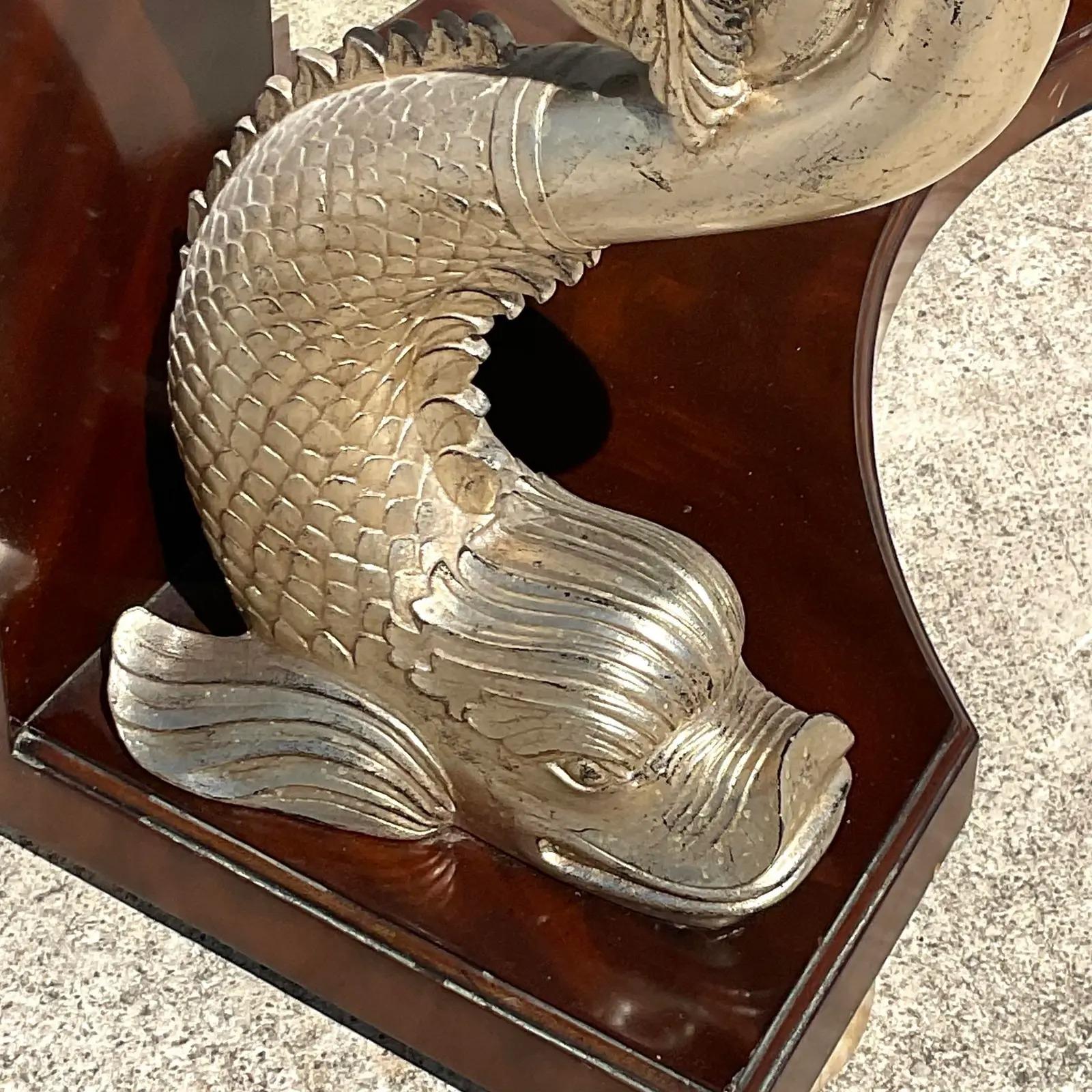 A stunning vintage Regency console table. Made by the iconic Maitland Smith group. A chic carved pair of silver koi fish with a tessellated stone top. Inset beveled mirror. Acquired from a Palm Beach estate