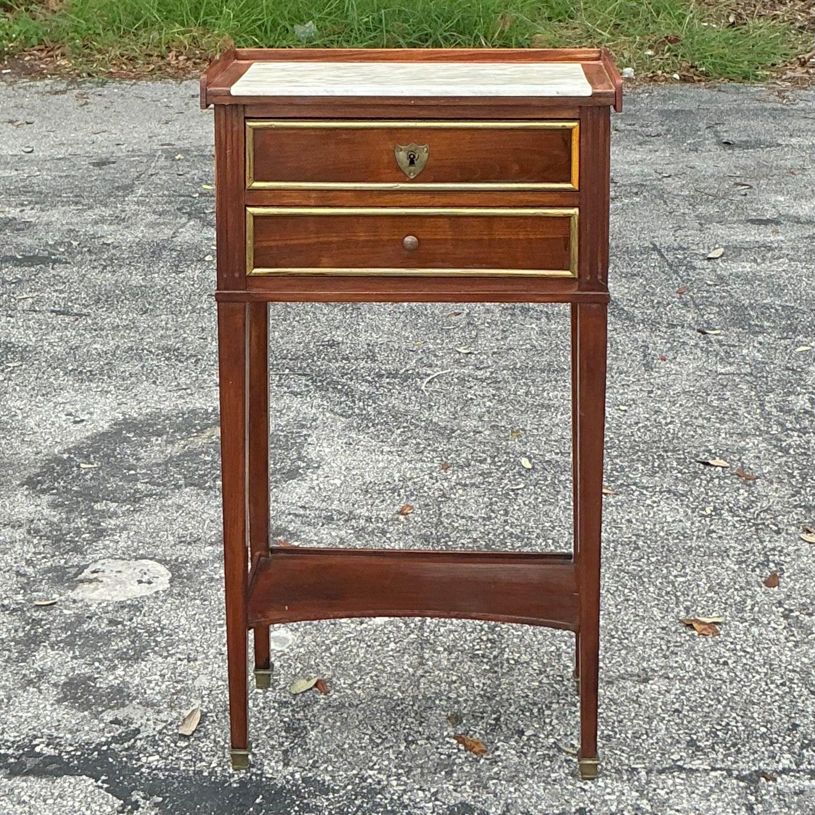 Infondi nei tuoi interni l'eleganza senza tempo dell'epoca Regency con questo squisito tavolo da telefono vintage. La sua silhouette sottile e sofisticata è coronata da un lussuoso piano in marmo color crema, che si integra perfettamente con i toni