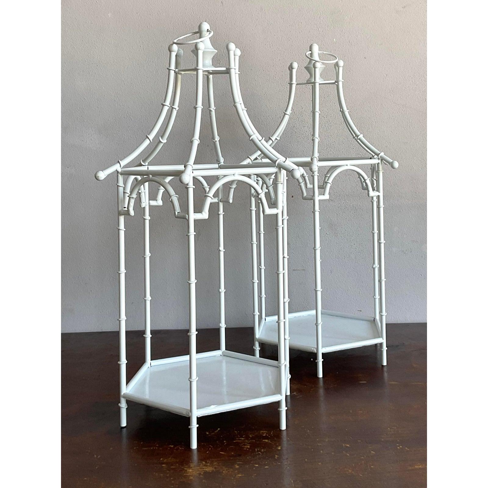 This elegant pair of vintage lanterns perfectly captures the graceful whimsy of the Chinoiserie and Hollywood Regency styles. Crafted from slender white painted metal, the design mimics the delicate joints and texture of bamboo, expertly formed into
