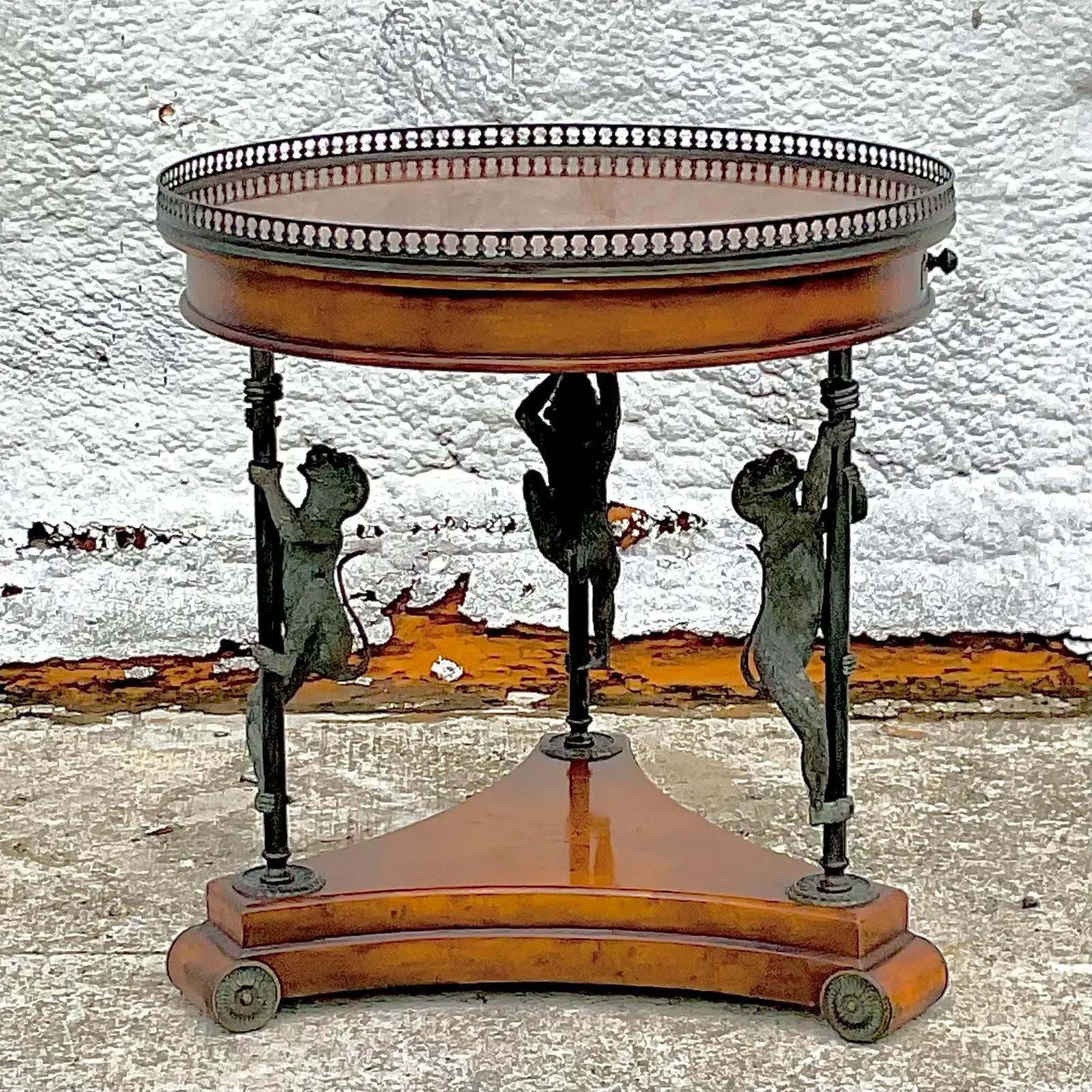 Fantastic vintage Regency side table. Beautiful Burl wood with leather detail. Chic monkey appliqué Bouilotte shape with a pull out drinks tray. Acquired from a Palm Beach estate.