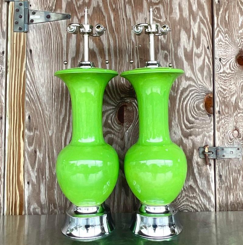 An incredible pair of vintage Glazed ceramic table lamps. Monumental in size and drama. Brilliant apple green color with a high gloss finish. Fully restored with all new wiring, hardware and polished chrome plinths. Acquired from a Palm Beach estate