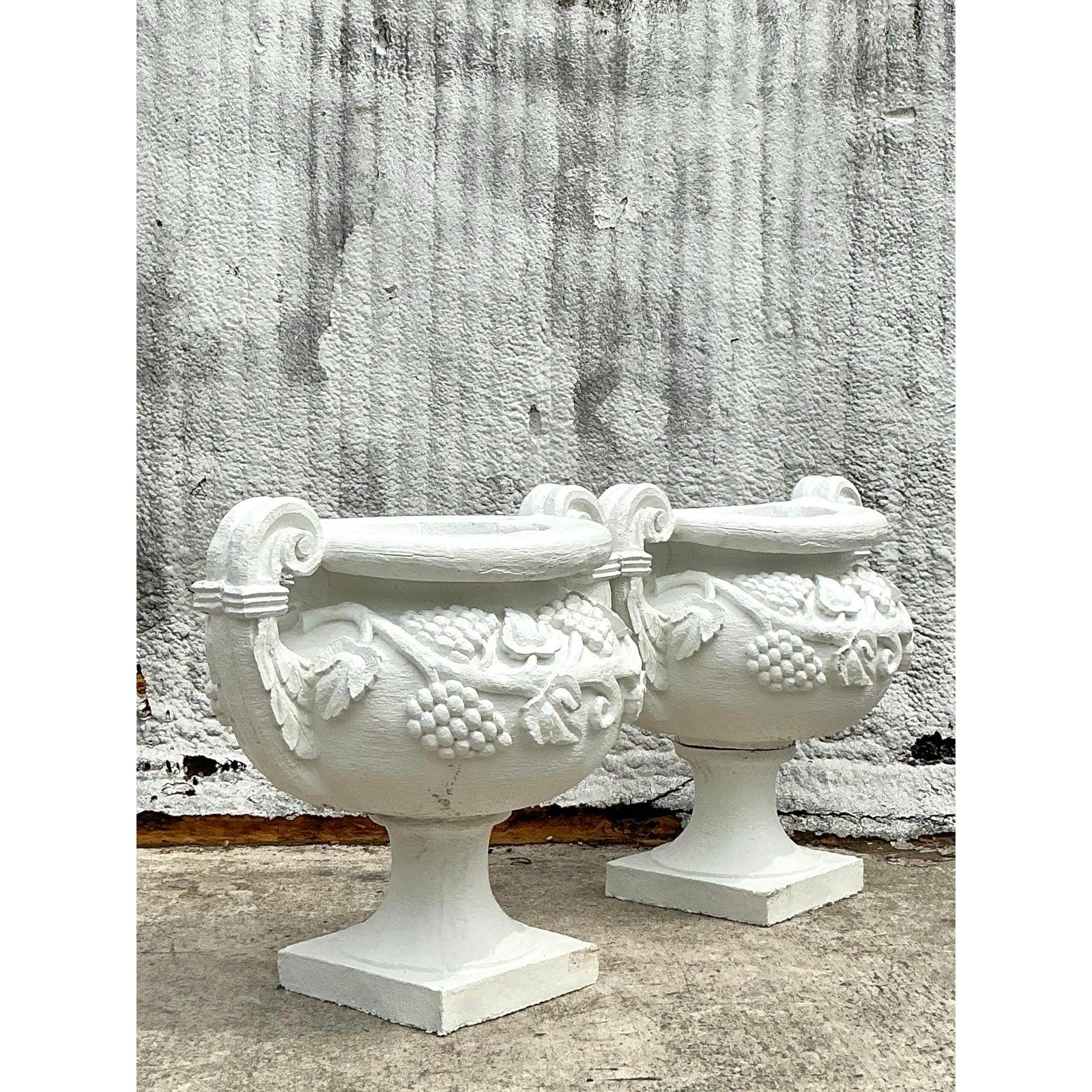 Eleva il tuo spazio all'aperto o all'interno con questa coppia di urne monumentali in stile Vintage Regency, magistralmente realizzate in calcestruzzo e rifinite in una tonalità bianca e brillante. Ogni urna presenta dettagli in rilievo con motivi