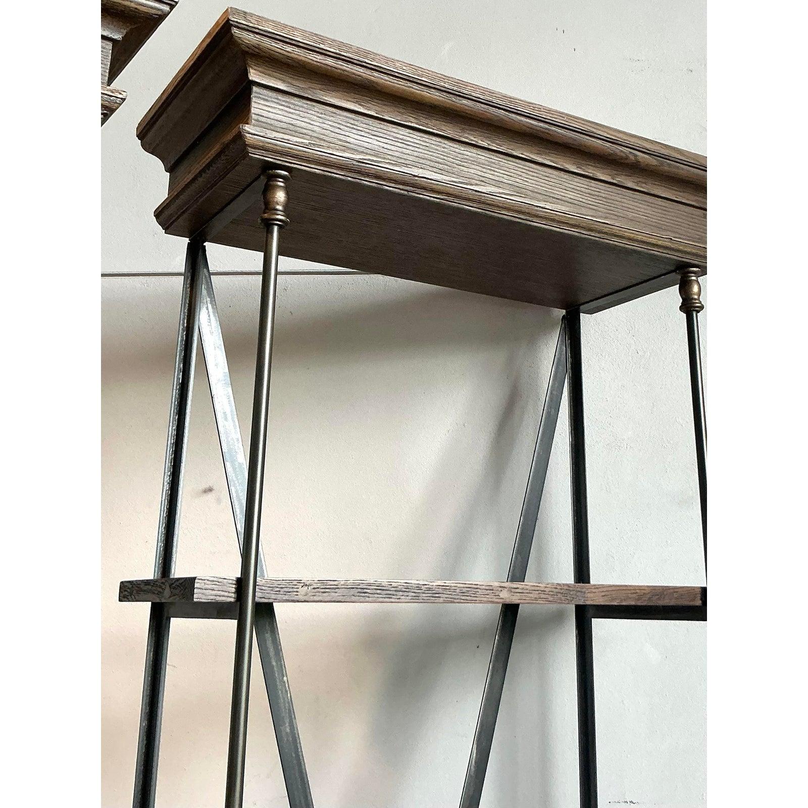 Command attention with this exceptional pair of vintage monumental étagères, seamlessly blending the robust aesthetic of industrial design with a touch of Hollywood Regency sophistication. Each towering unit features a striking black metal frame
