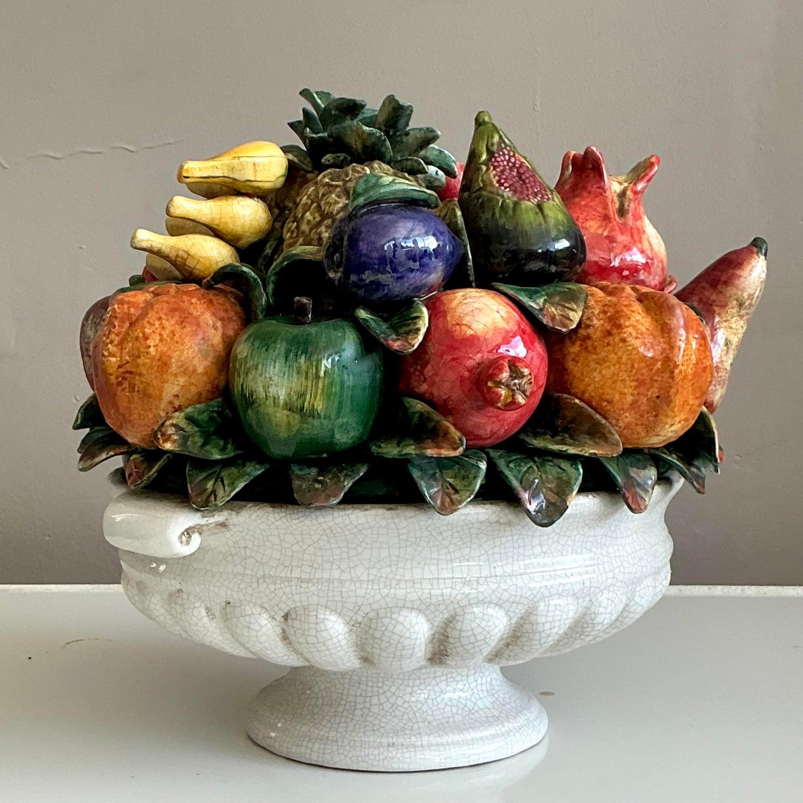 Esempio di maiolica classica italiana, questo monumentale centrotavola di frutta offre un'opulenza senza tempo e un'arte vibrante. Meticolosamente scolpito e smaltato a mano, presenta una ricca composizione di frutta realistica - tra cui melograni,