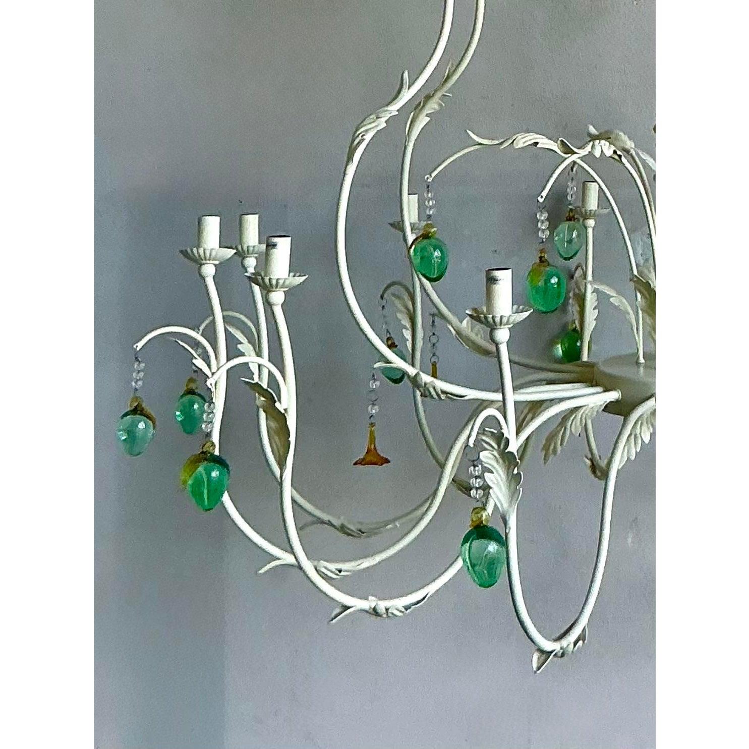 Elevate your space with this magnificent Vintage Regency Chandelier, a true statement piece that blends classic elegance with a touch of whimsy. Crafted with an ornate cream-hued metal frame adorned with delicate leaf motifs, this chandelier exudes
