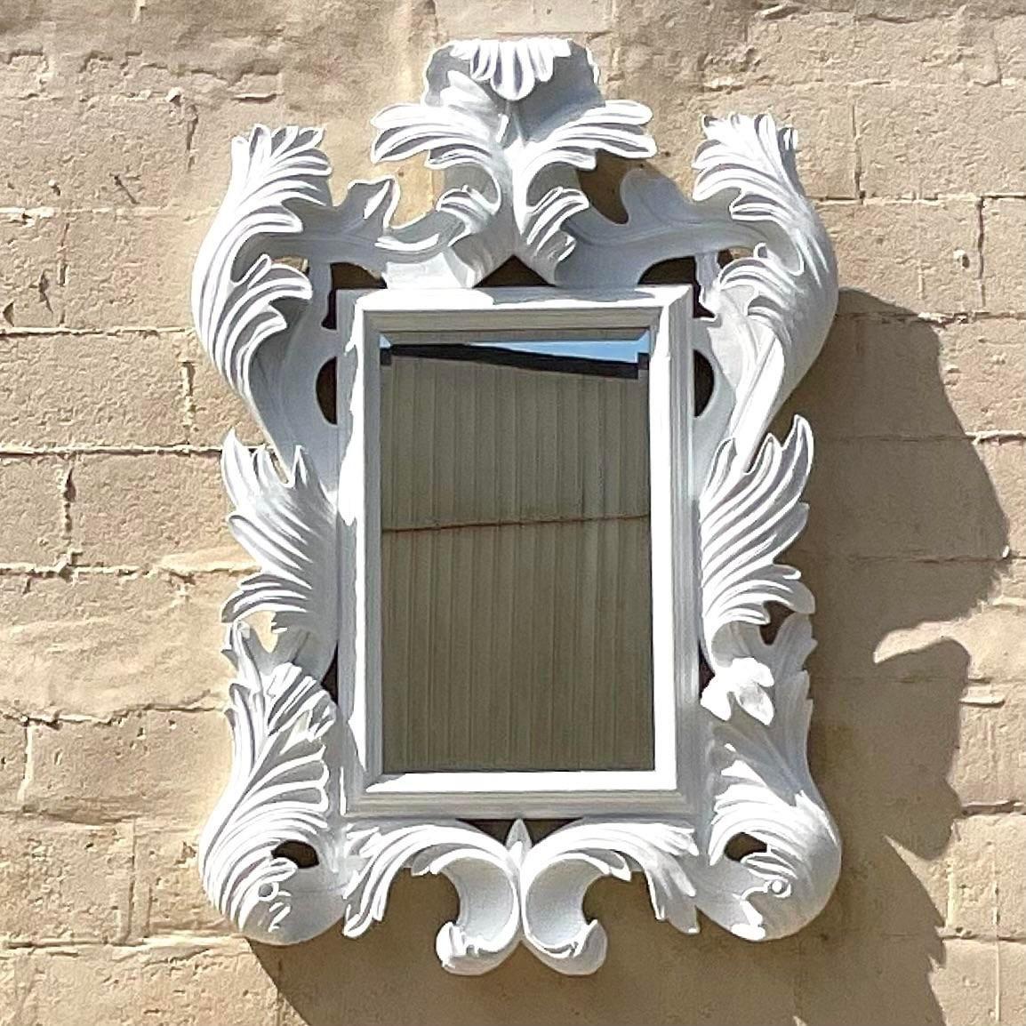 A stunning vintage Regency wall mirror. Made by the iconic Marge Carson group. A wild and dramatic Rococo style with an amazing flourish design. Finished in a matted plaster white. Acquired from a Palm Beach estate.