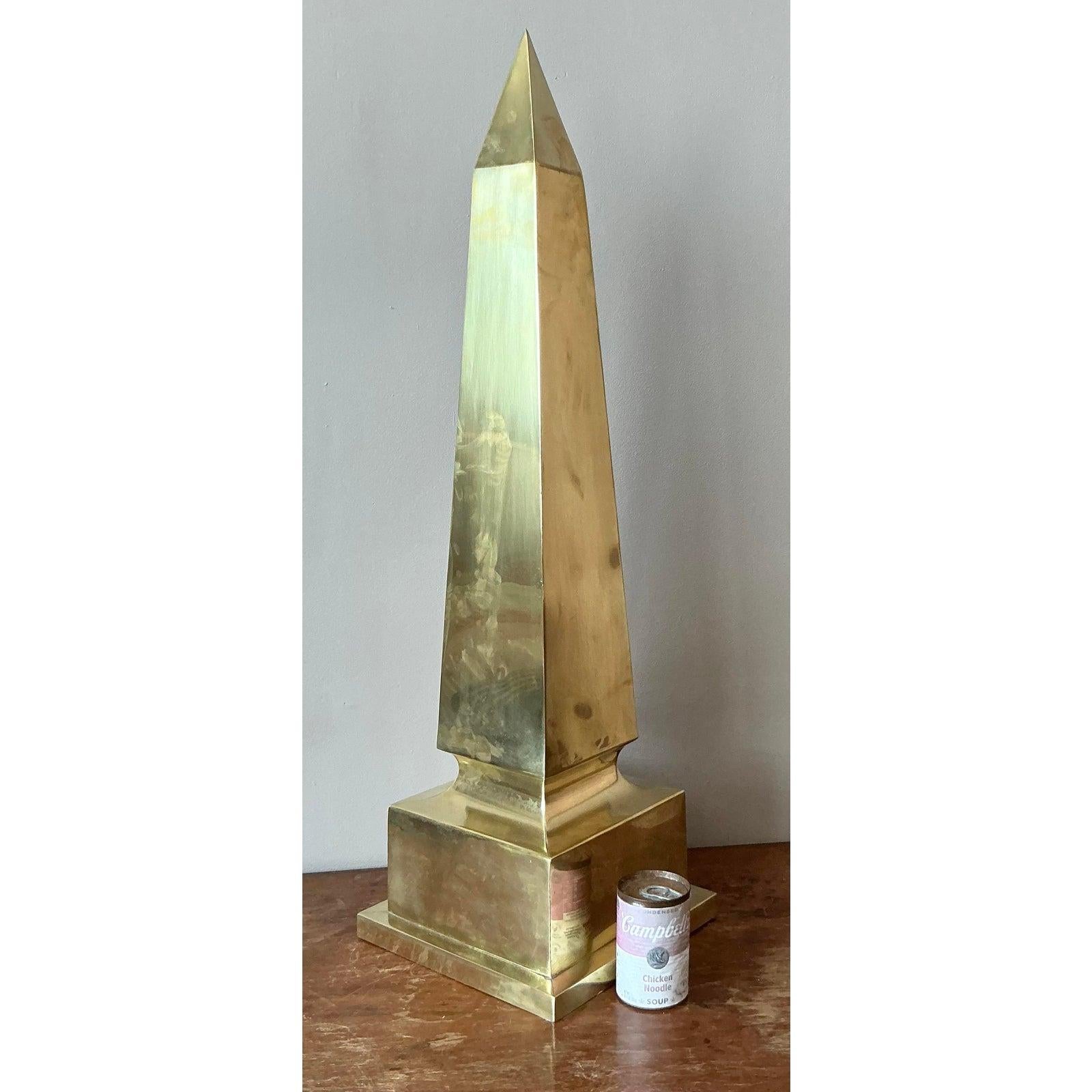 Anchor your interior with the stately grandeur of this monumental vintage brass obelisk. A timeless symbol of classical elegance, this piece pays homage to the grand obelisks of antiquity, a favorite motif of Neoclassical and Regency design