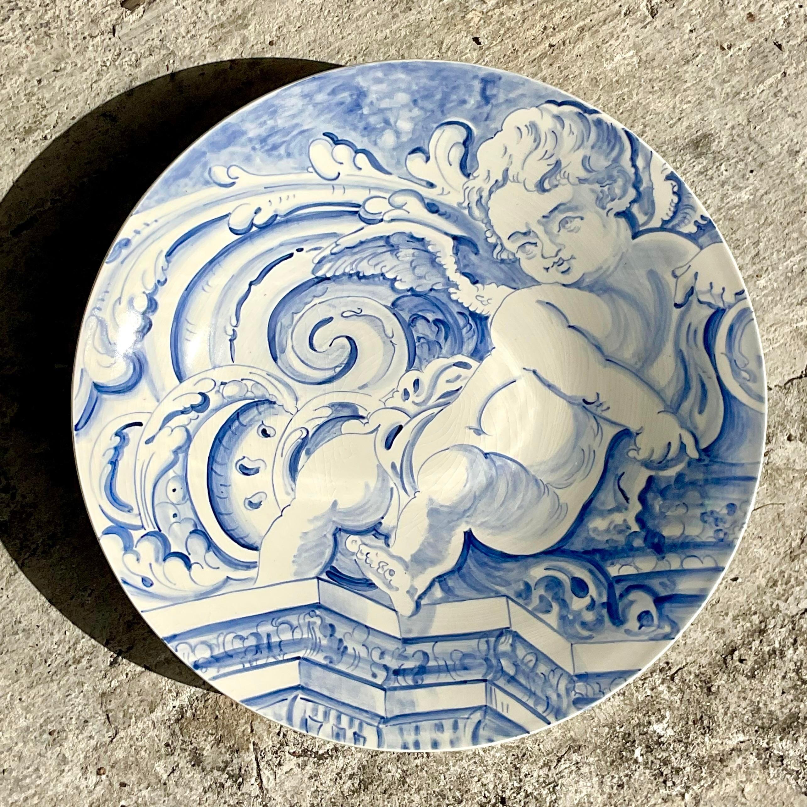 A fantastic vintage Regency decorative plate. A fabulous hand painted cherub in an iconic blue and white design. Made and signed by the artist Robert Walters