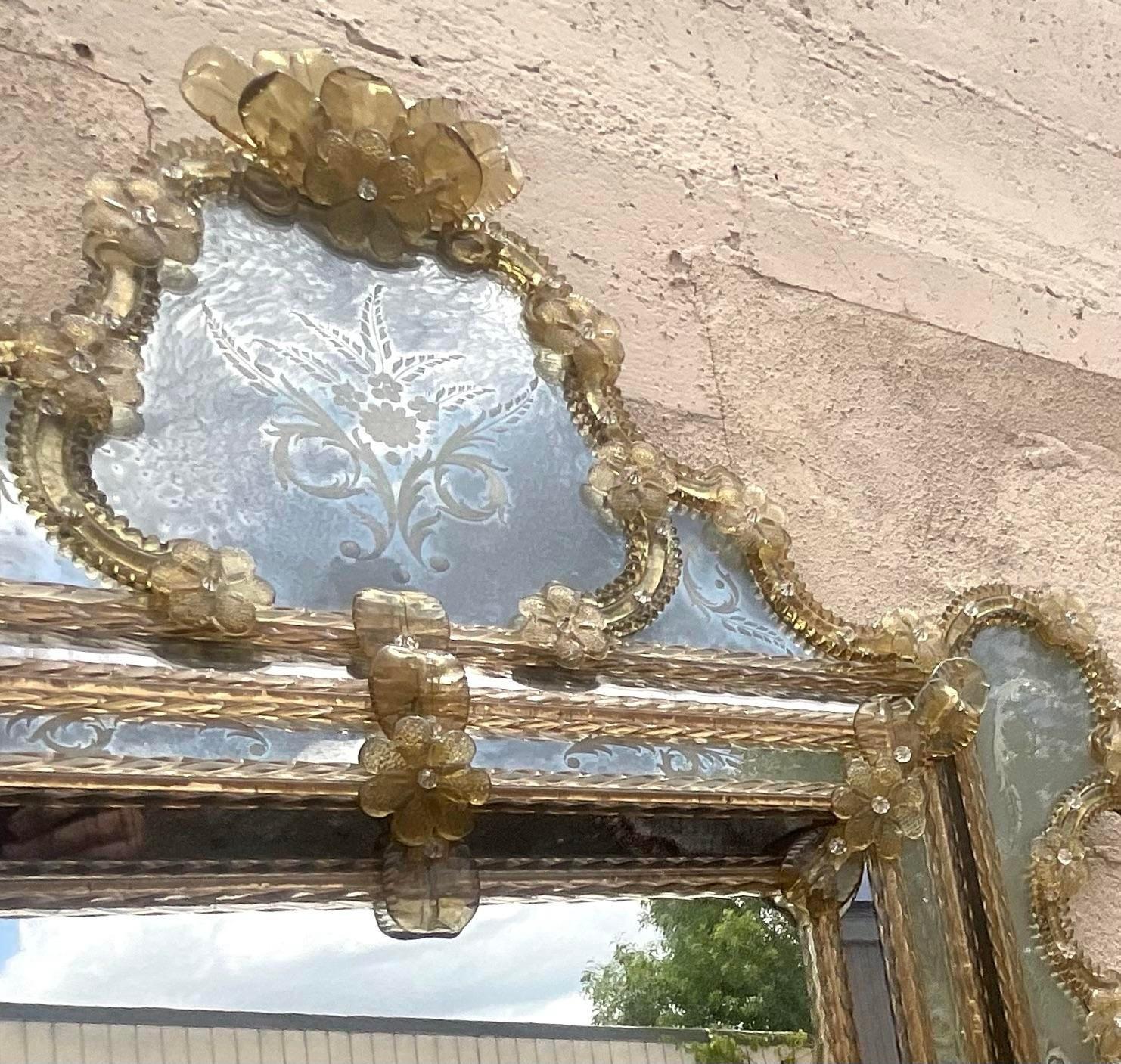 Ce miroir vénitien monumental Vintage Regency rehausse votre décoration intérieure. Exhalant grandeur et sophistication, ce miroir présente des détails complexes et une présence majestueuse, alliant l'élégance du design vénitien au style américain