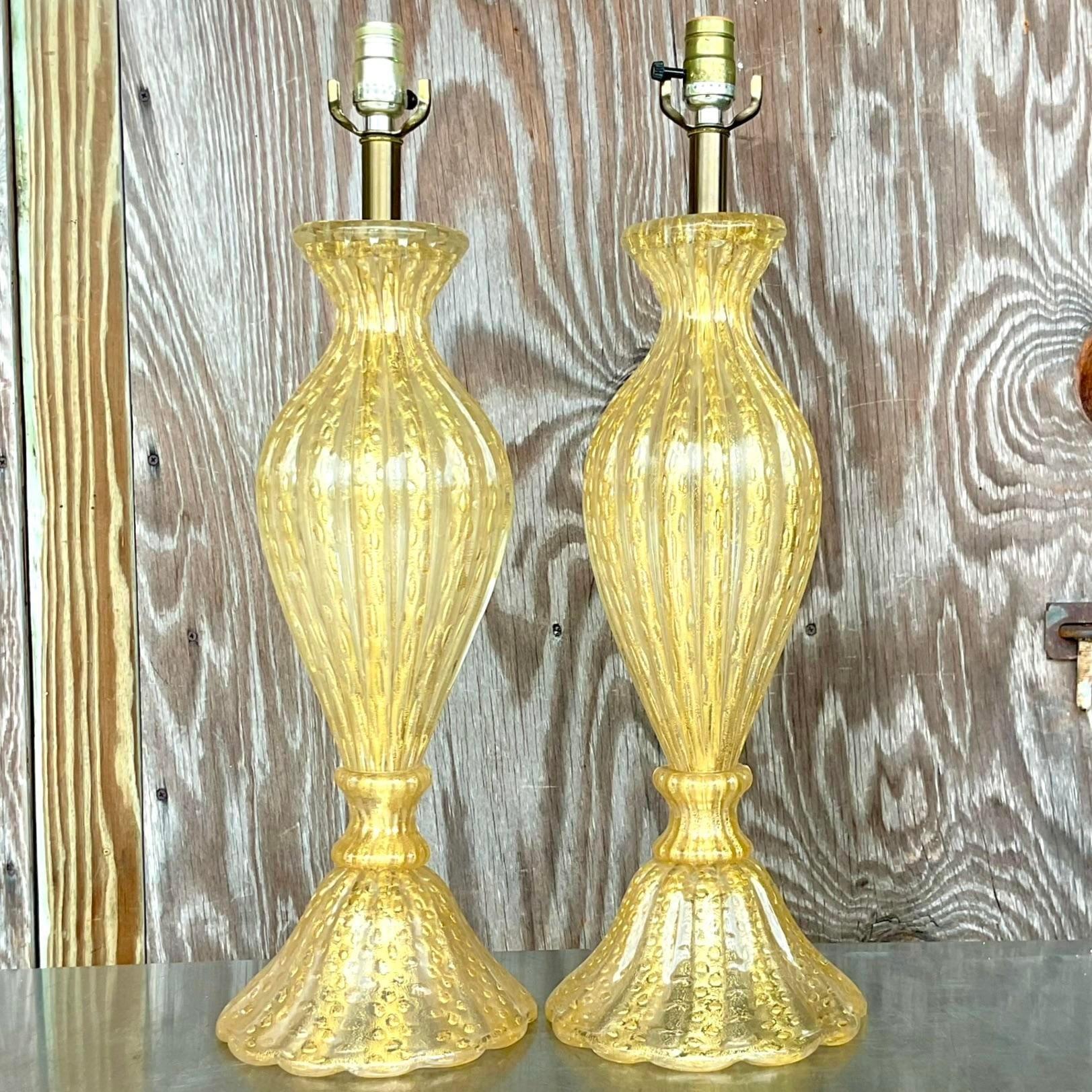A fabulous pair of vintage Regency table lamps. Made by the Murano group in Italy. Beautiful gold coloration makes it the perfect neutral for so many spaces. Acquired from a Palm Beach estate. 
