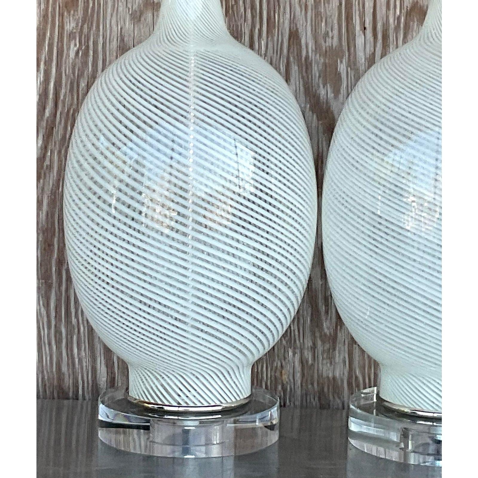 A stunning pair of vintage Italian Murano lamps. A beautiful swirl design in a pale celadon color. Fully restored with all new wiring, hardware and lucite plinths. Acquired from a Palm Beach estate.