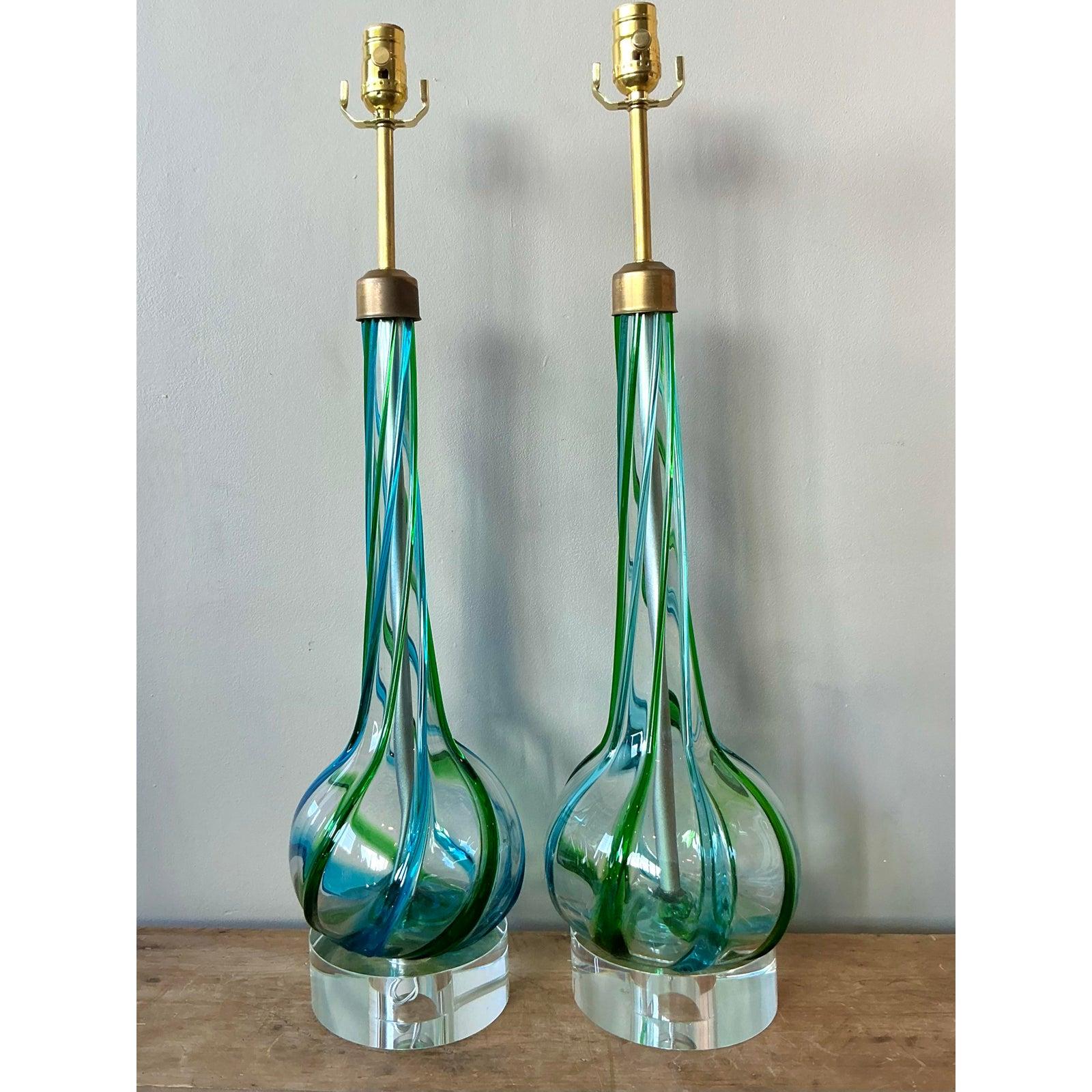 Cette spectaculaire paire de lampes de table évoque l'art vibrant et le flair de haut niveau des souffleurs de verre italiens de Murano, caractéristiques des années 1960 et 1970. Chaque lampe présente une silhouette allongée et effilée avec une base