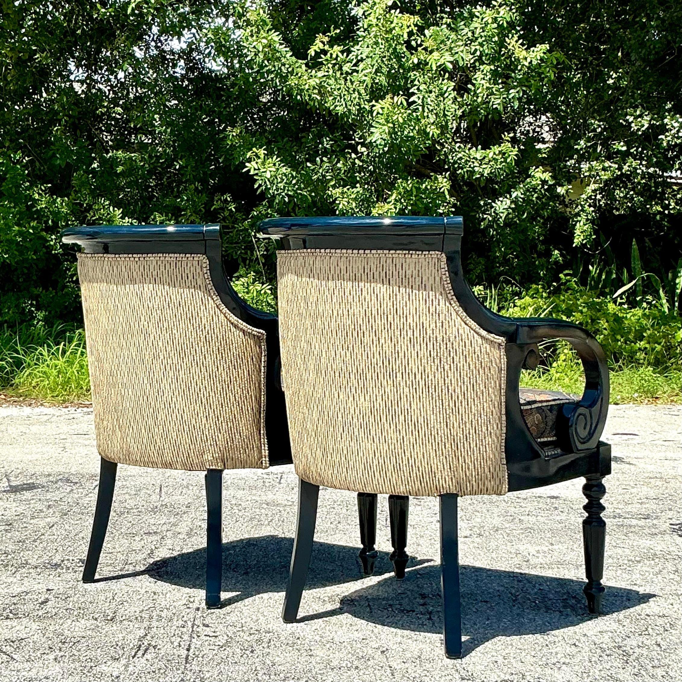 The Vintage Regency Navy Lacquered Paisley Lounge Chairs are a stunning pair that combine bold elegance with a touch of whimsy. These chairs feature a rich navy lacquered finish on their wooden frames, which are often adorned with classic