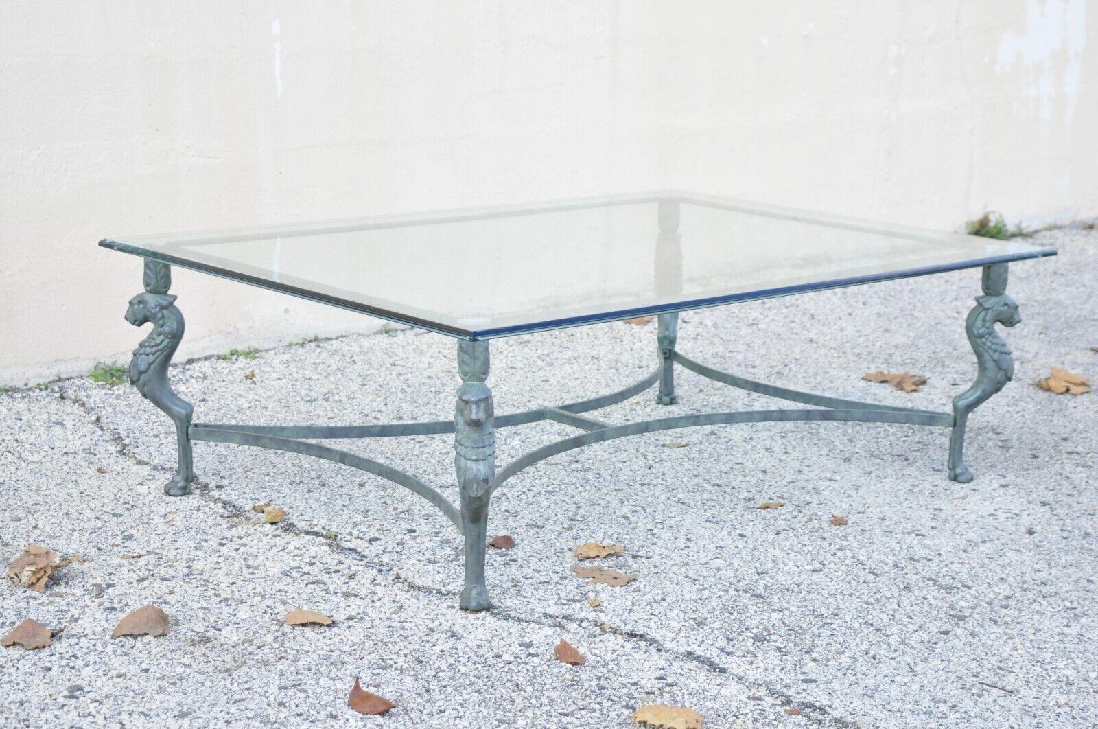 Vintage Regency Neoclassical style green iron and glass lion coffee table. Item features figural lion form legs with paw feet, green distress painted finish, wrought cast iron construction, beveled glass top, very nice vintage item, great style and