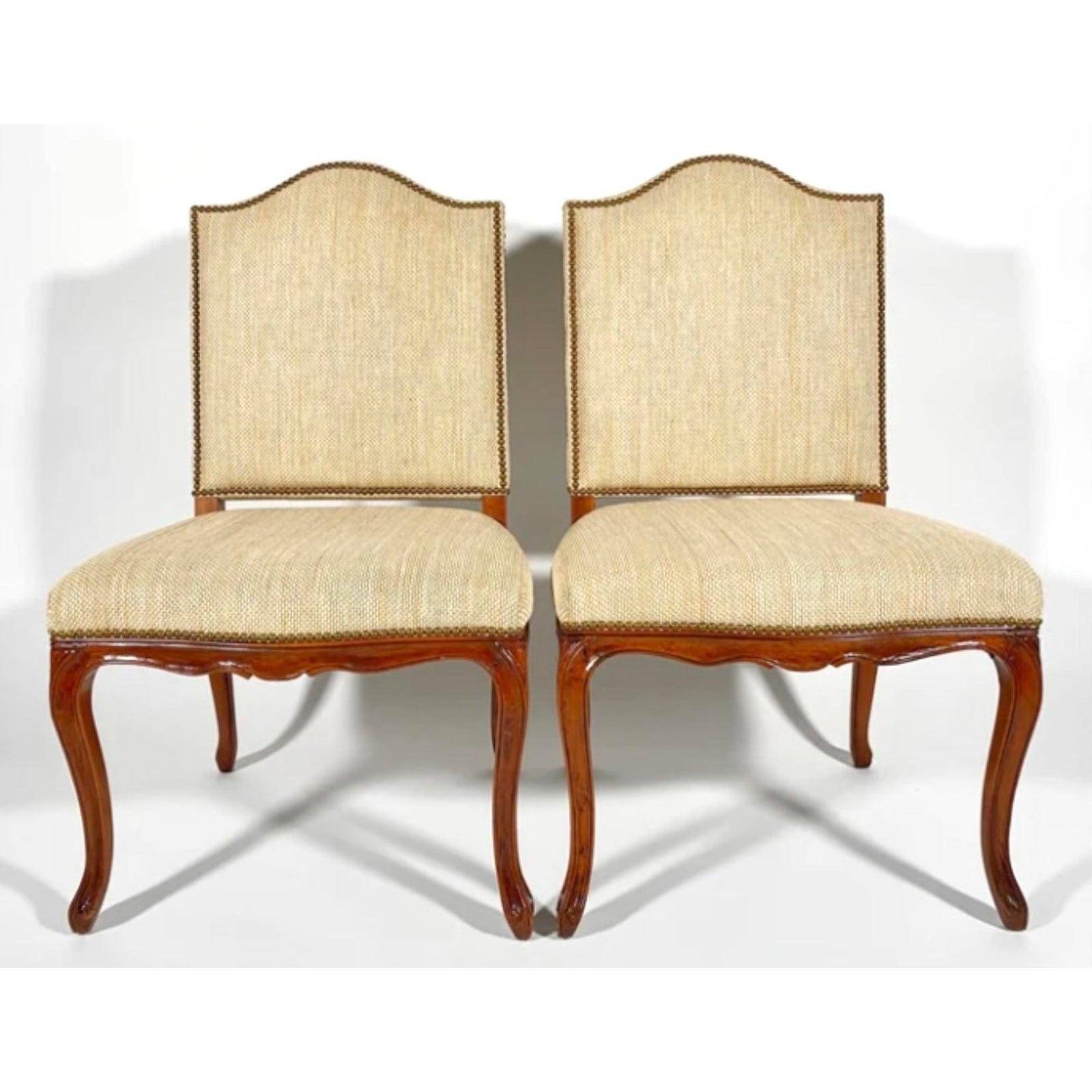 A fabulous pair of vintage Regency side chairs. Made by the iconic Niermann Weeks group. Beautiful hand carved detail with a raffia like upholstery and nailhead trim. Contrasting neutral plaid backs. Acquired from a Palm Beach estate.