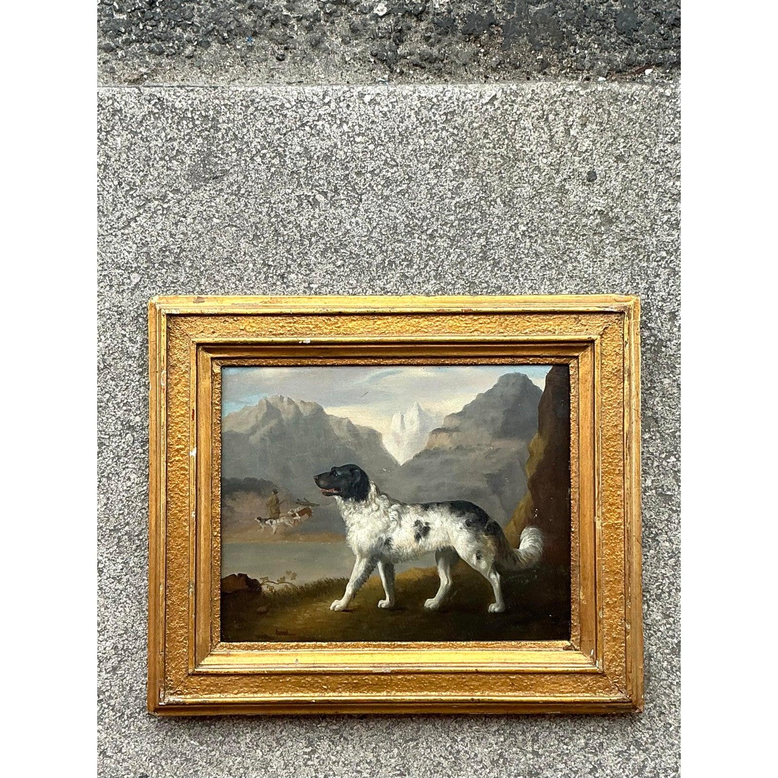 A timeless depiction of loyalty and grace, this vintage Regency oil painting features a poised black-and-white hunting dog set against a dramatic mountain landscape. With finely rendered brushwork, the artist captures not only the noble posture of