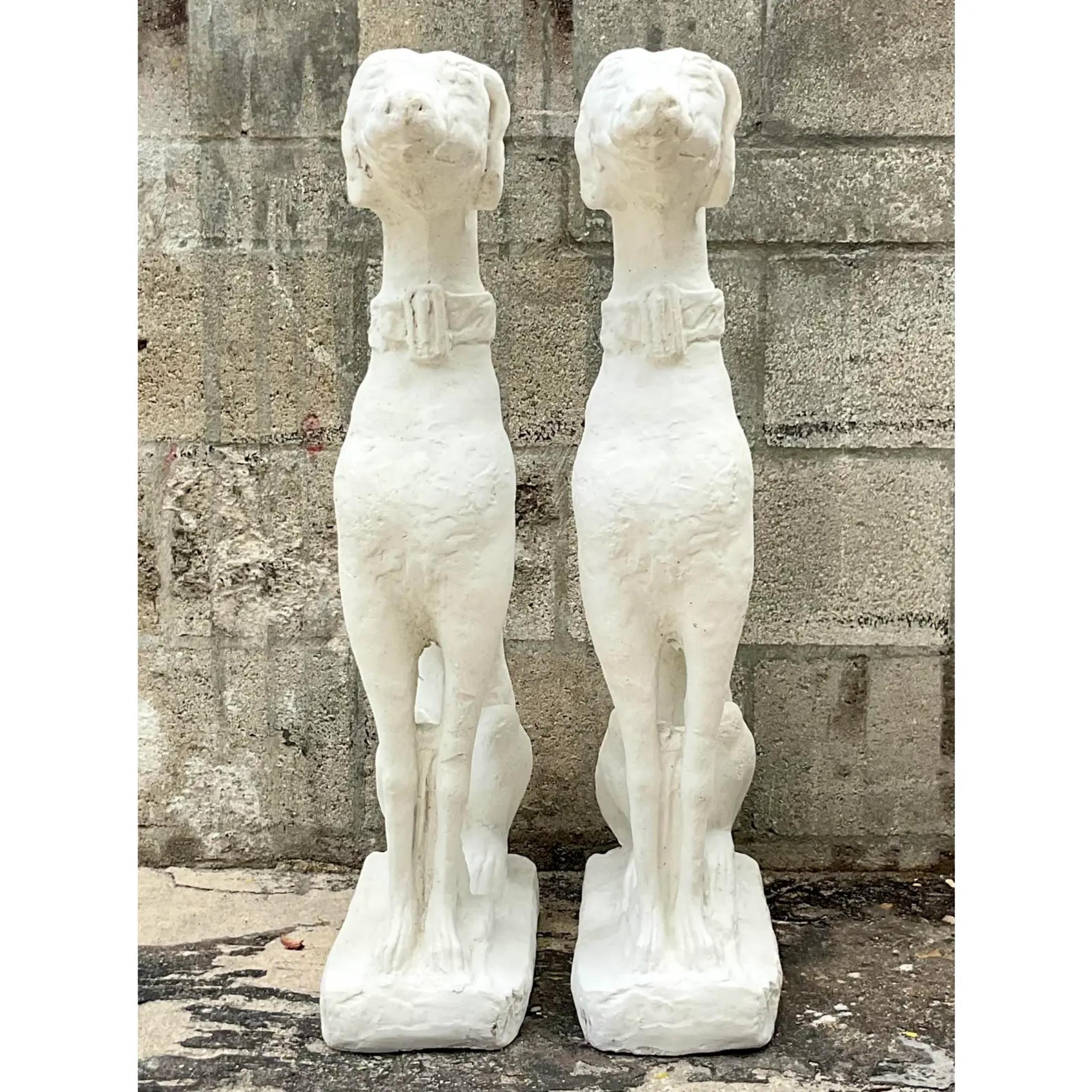 Vintage Regency pair of dogs. Tall and handsome greyhounds. Made of a solid cement that has been painted white. Acquired from a Palm Beach estate