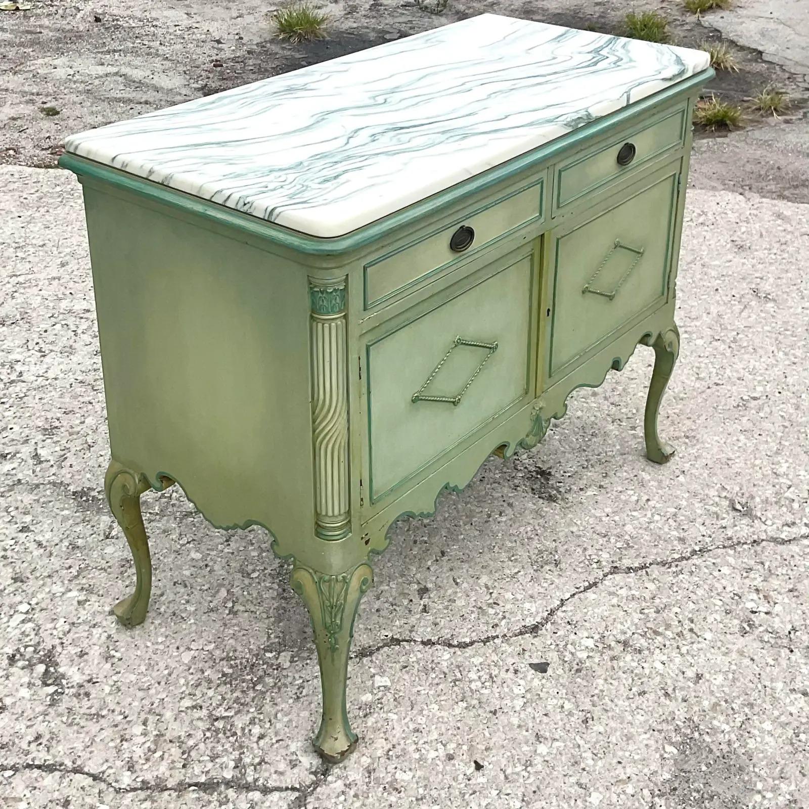 Fabulous vintage Regency sideboard. A beautiful painted cabinet with lots of hand carved detail. Fabulous marble slab on top. Interior drawers make this ideal for linen storage. Acquired from a Palm Beach estate.