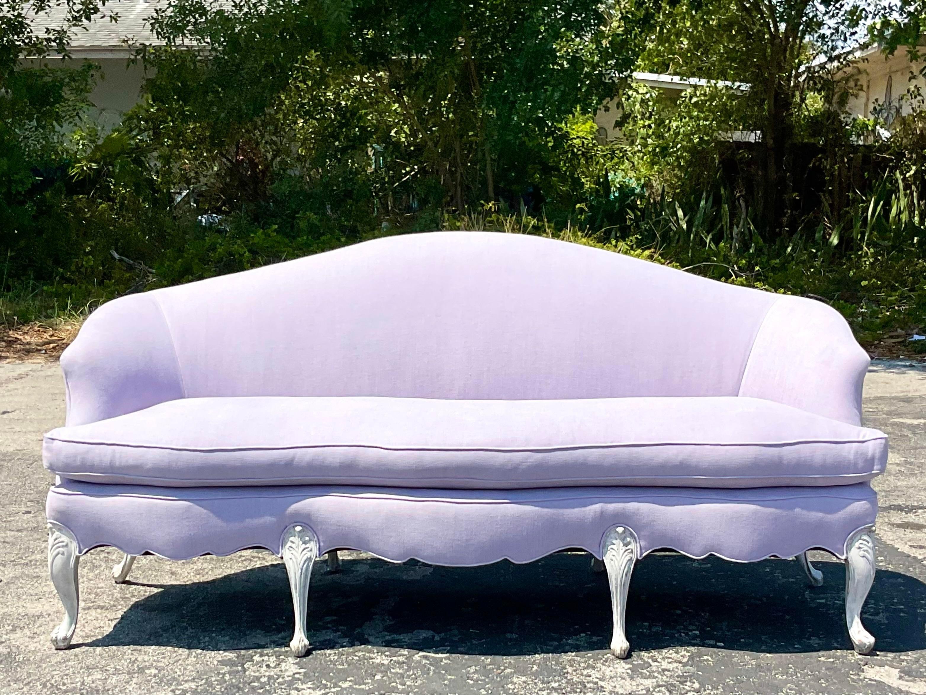 An exceptional vintage Regency sofa. A chic camelback shape that has been recently updated with cerused legs and the most gorgeous pale lavender upholstery. A real showstopper. Acquired from a Palm Beach estate.