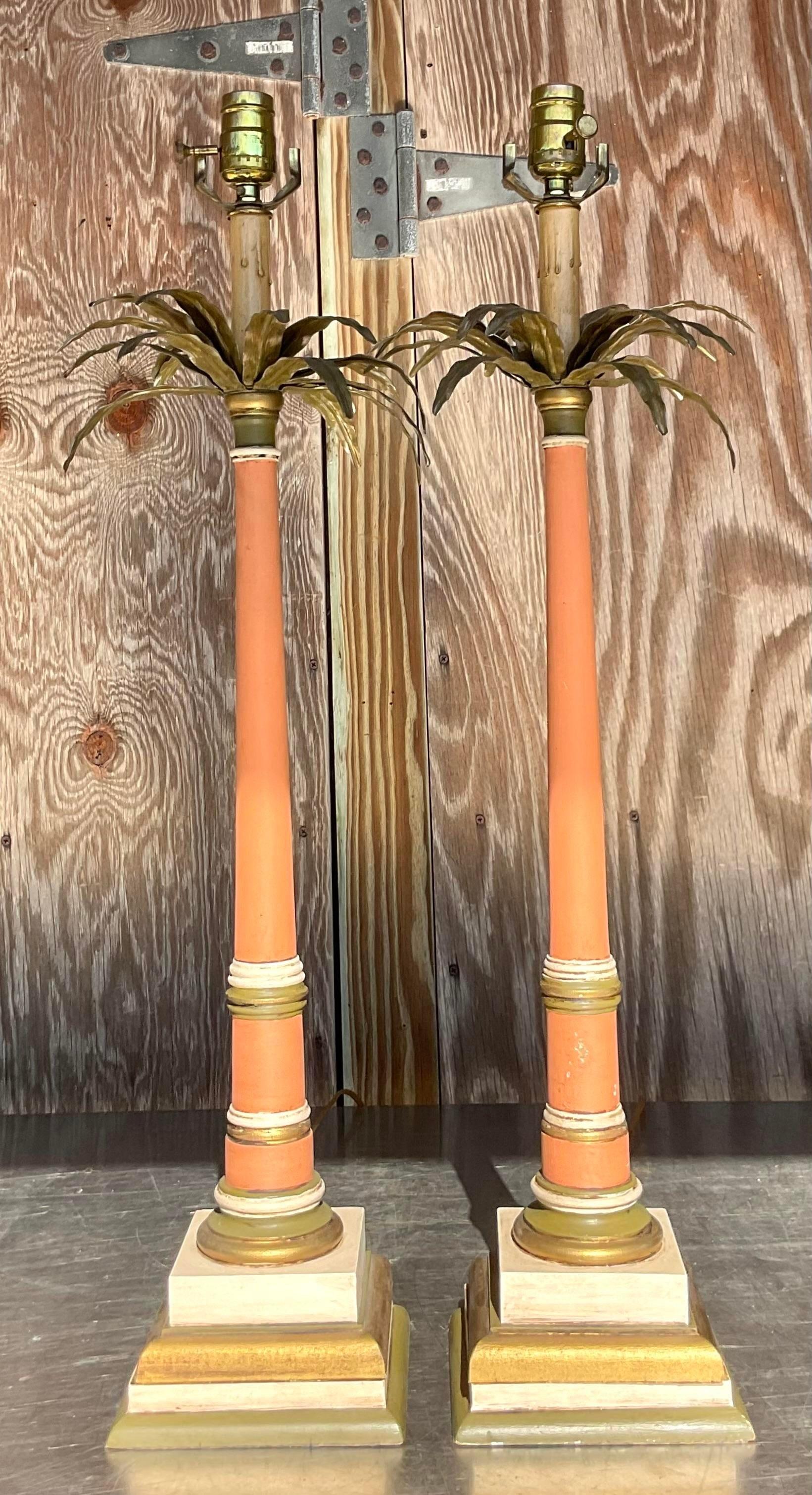 A fabulous pair of vintage Coastal table lamps. A chic brass palm tree topper on a classic stacked candlestick design. A fantastic original painted final with a gorgeous all over patina from time. Acquired from a Palm Beach estate. 