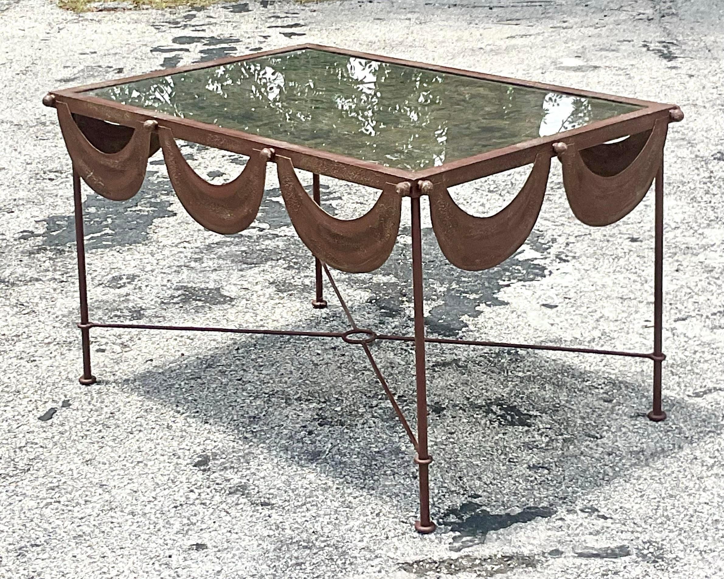 Elevate your living space with our Vintage Regency Patinated Metal Swag Coffee Table. Crafted in the USA, this exquisite piece showcases American craftsmanship at its finest, blending regal elegance with a touch of vintage allure to create a