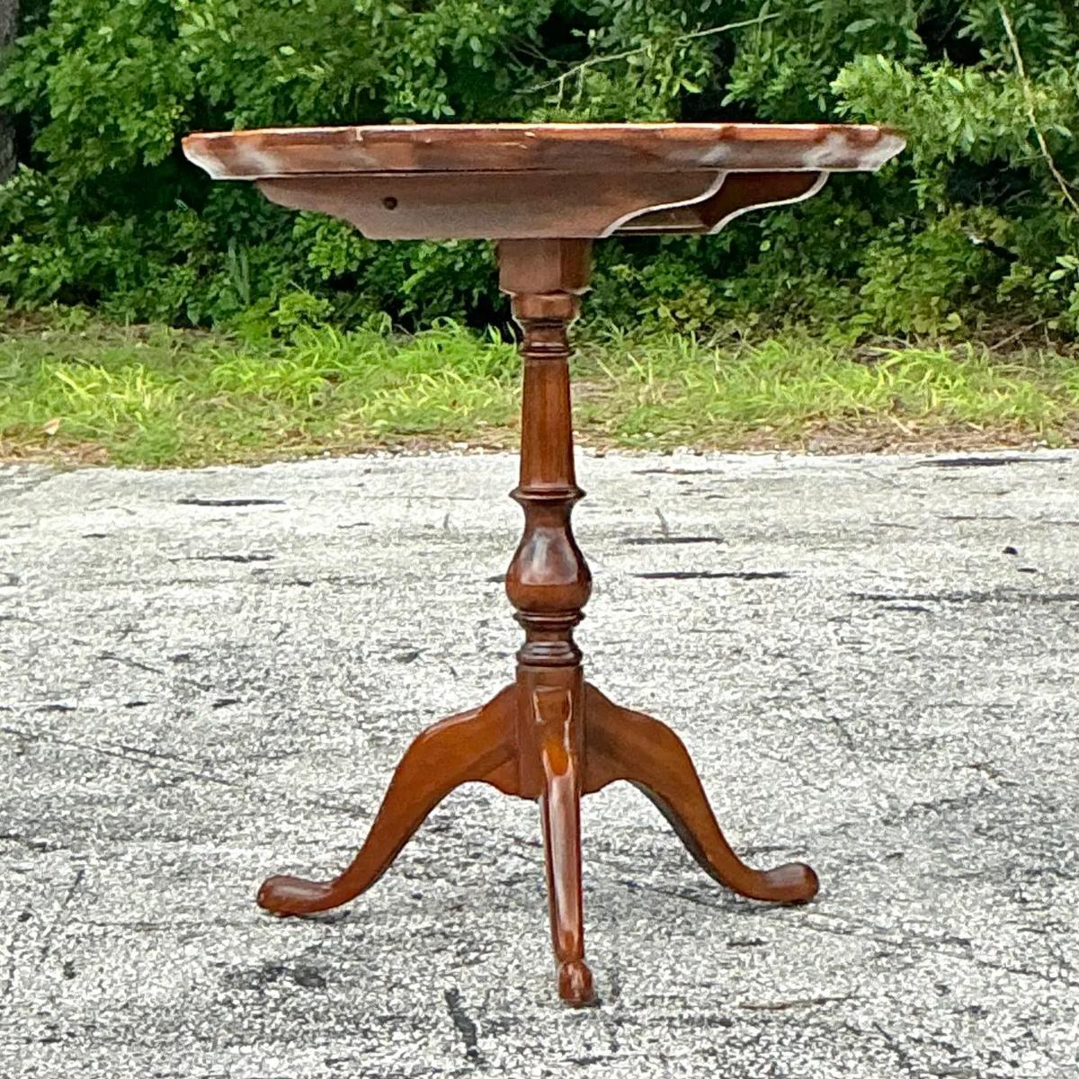 Add a touch of classic elegance to your home with this Vintage Regency Pie Crust Tilt Table. Featuring a beautifully scalloped 