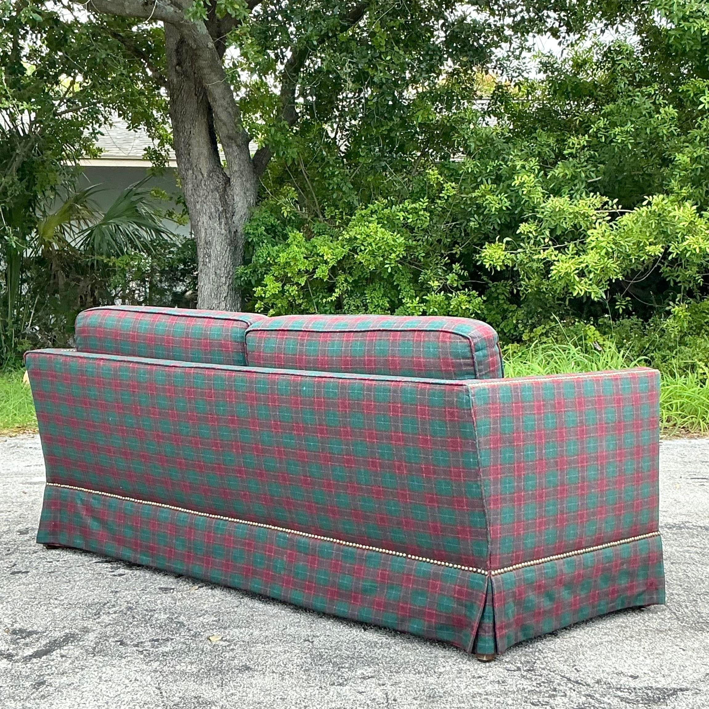 The Vintage Regency Plaid Nailhead Sofa captures the essence of American sophistication with its classic plaid upholstery and refined nailhead trim. This stylish piece offers both timeless elegance and superior comfort, making it a standout addition