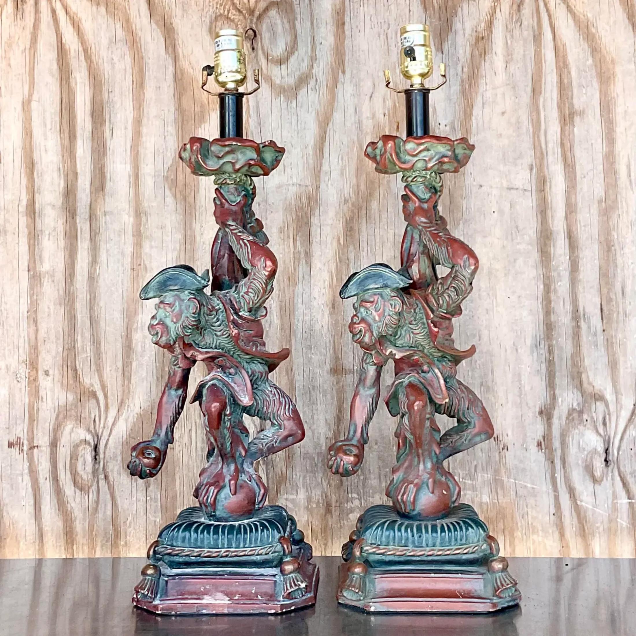A fabulous pair of vintage Regency plaster table lamps. A chic pair of monkeys in period dress. Finished in a deep ruby color with a moss green wash. Acquired from a Palm Beach estate