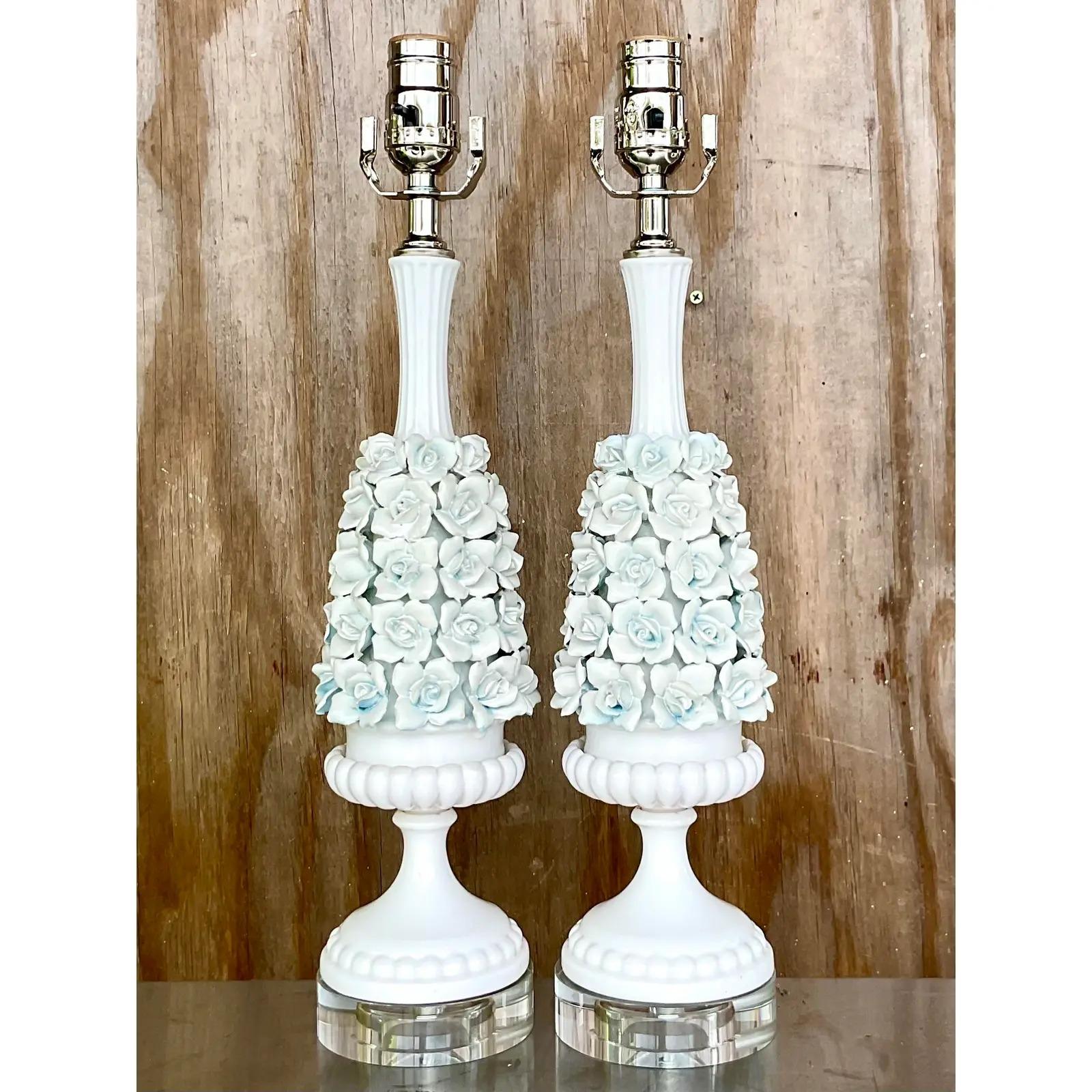 Gorgeous pair of chic roses lamps. Beautiful white flowers hand crafted in porcelain with the faintest light blue peeking through. Fully restored with all new wiring and hardware with crystal plinths. Acquired from a Palm Beach estate.