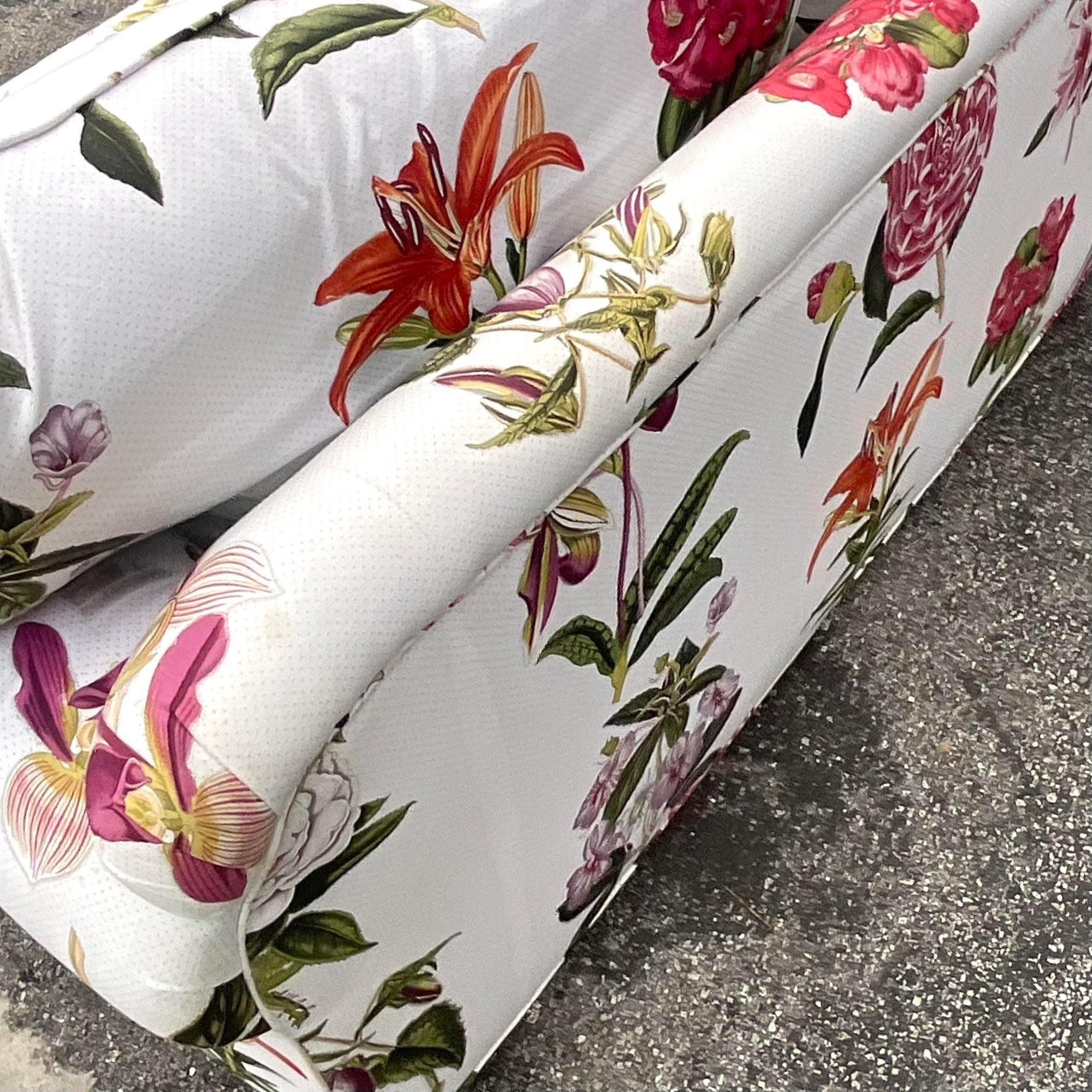 A fabulous vintage Regency loveseat. A chic printed floral in brilliant colors. A bright white for ground on a cotton jacquard. Coordinating pieces also available in the same print. Acquired from a Palm Beach estate.