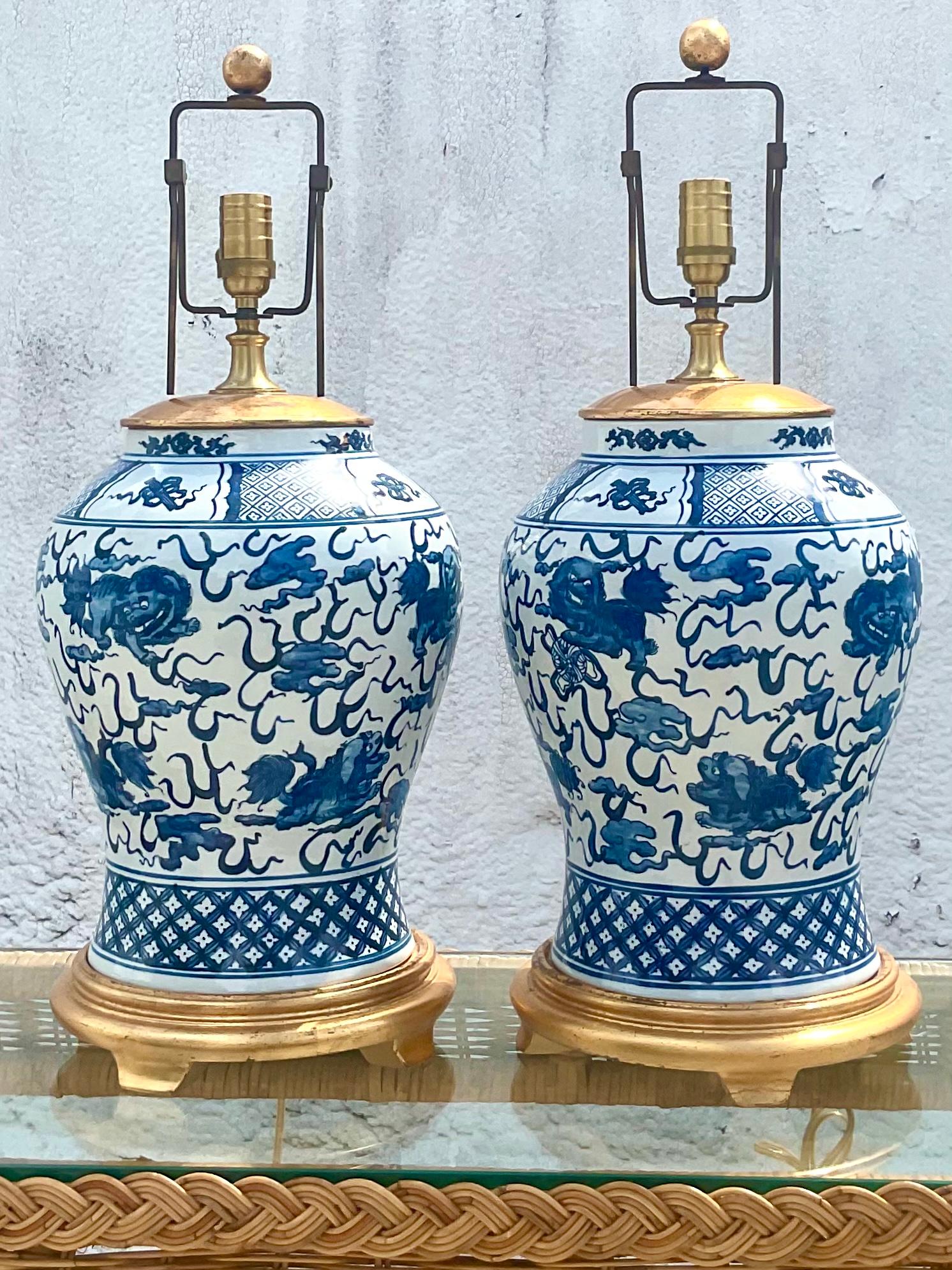 Fantastic pair of vintage Ralph Lauren table lamps. A beautiful ginger jar shape with the iconic foo dog design. Rests on a gilt base with brass hardware. Acquired from a Miami estate.