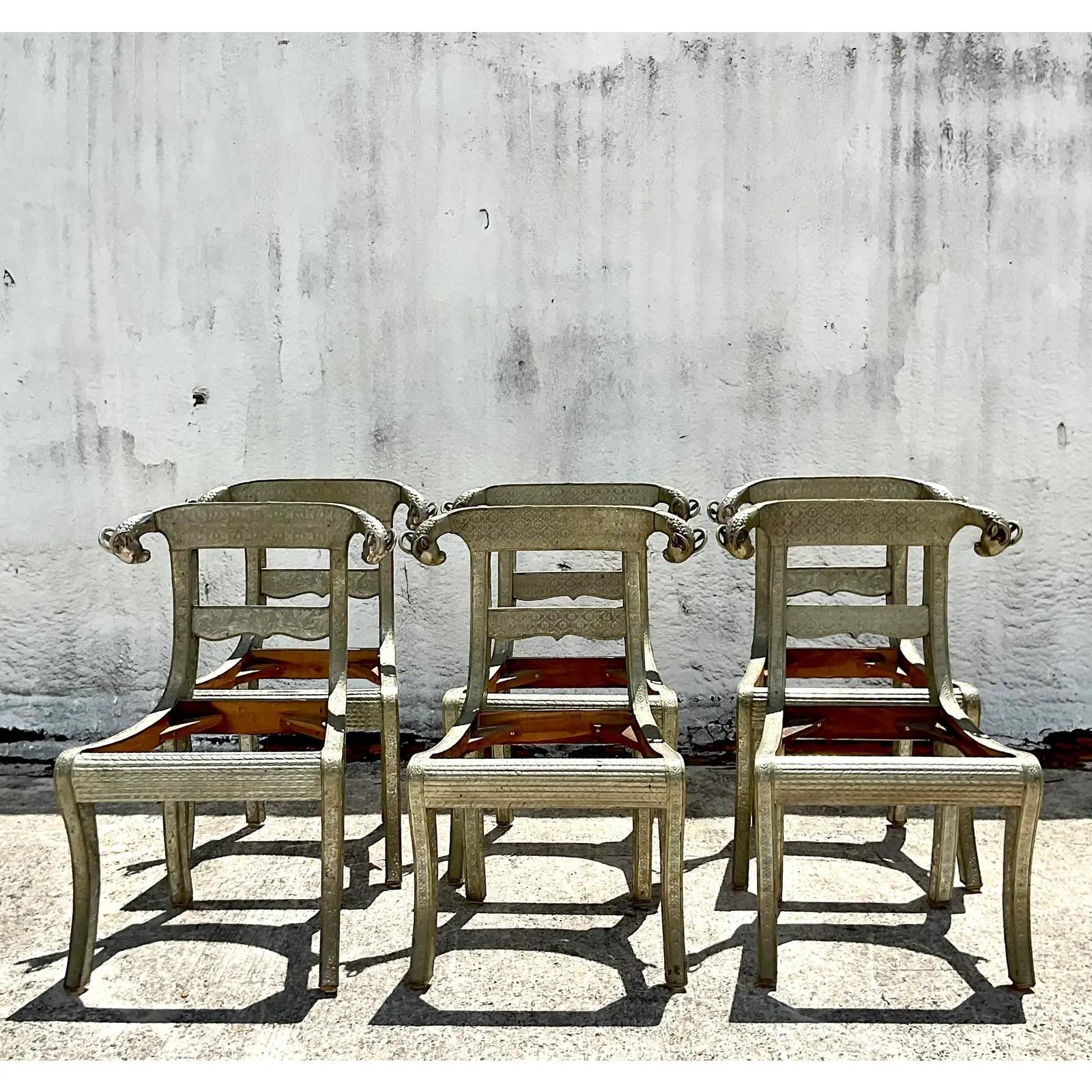 A spectacular set of six vintage Regency dining chairs. A wood frame wrapped in embossed silver metal with polished rams heads at the ends. The iconic Dowry wedding chair. The cushions are included, but they need to be recovered. Acquired from a