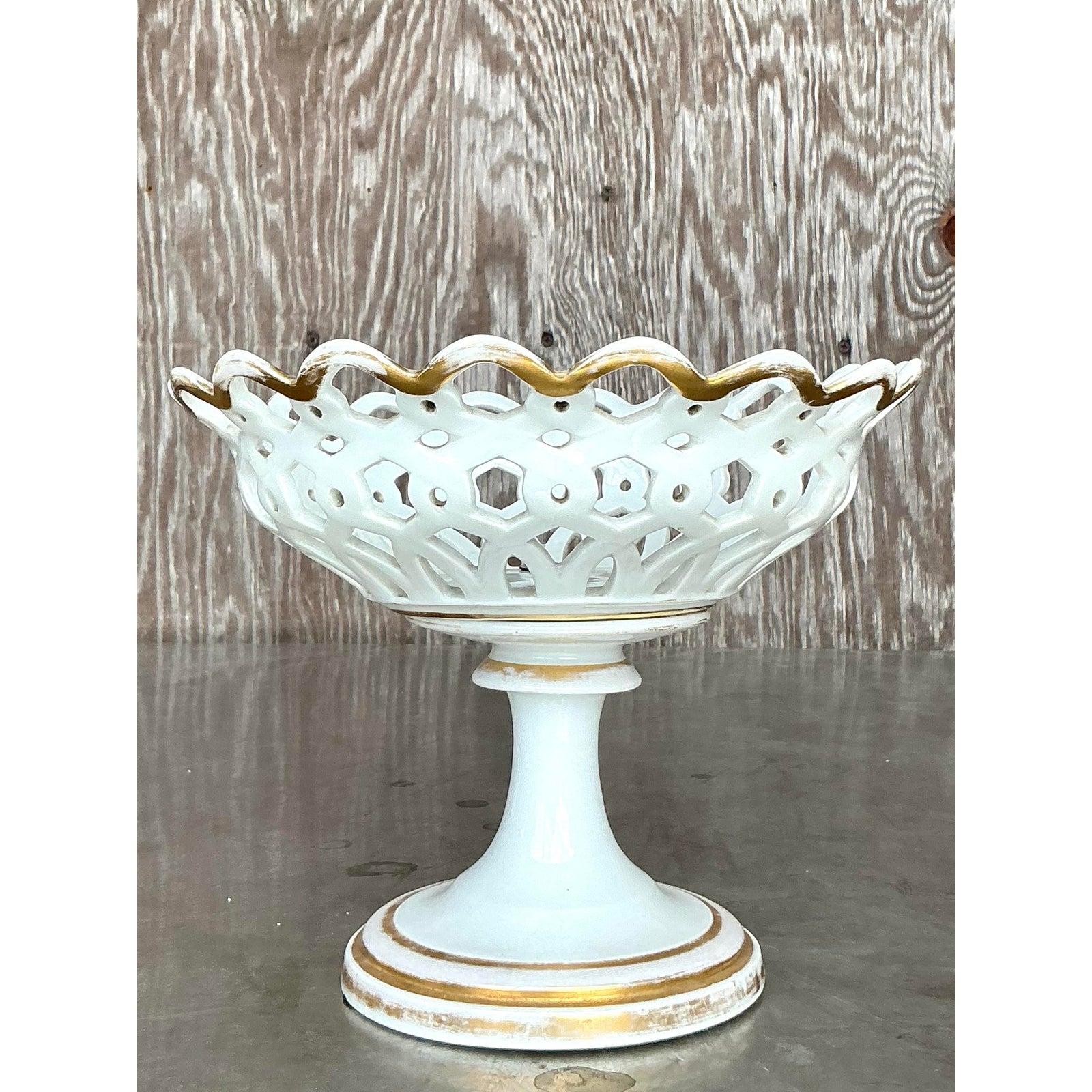 Verschönern Sie Ihre Einrichtung mit diesem eleganten Porzellankompott im Regency-Stil, das ein wunderschön durchbrochenes, netzartiges Gittermuster aufweist. Diese atemberaubende Schale auf einem Sockel ist mit zarten Goldverzierungen verziert und