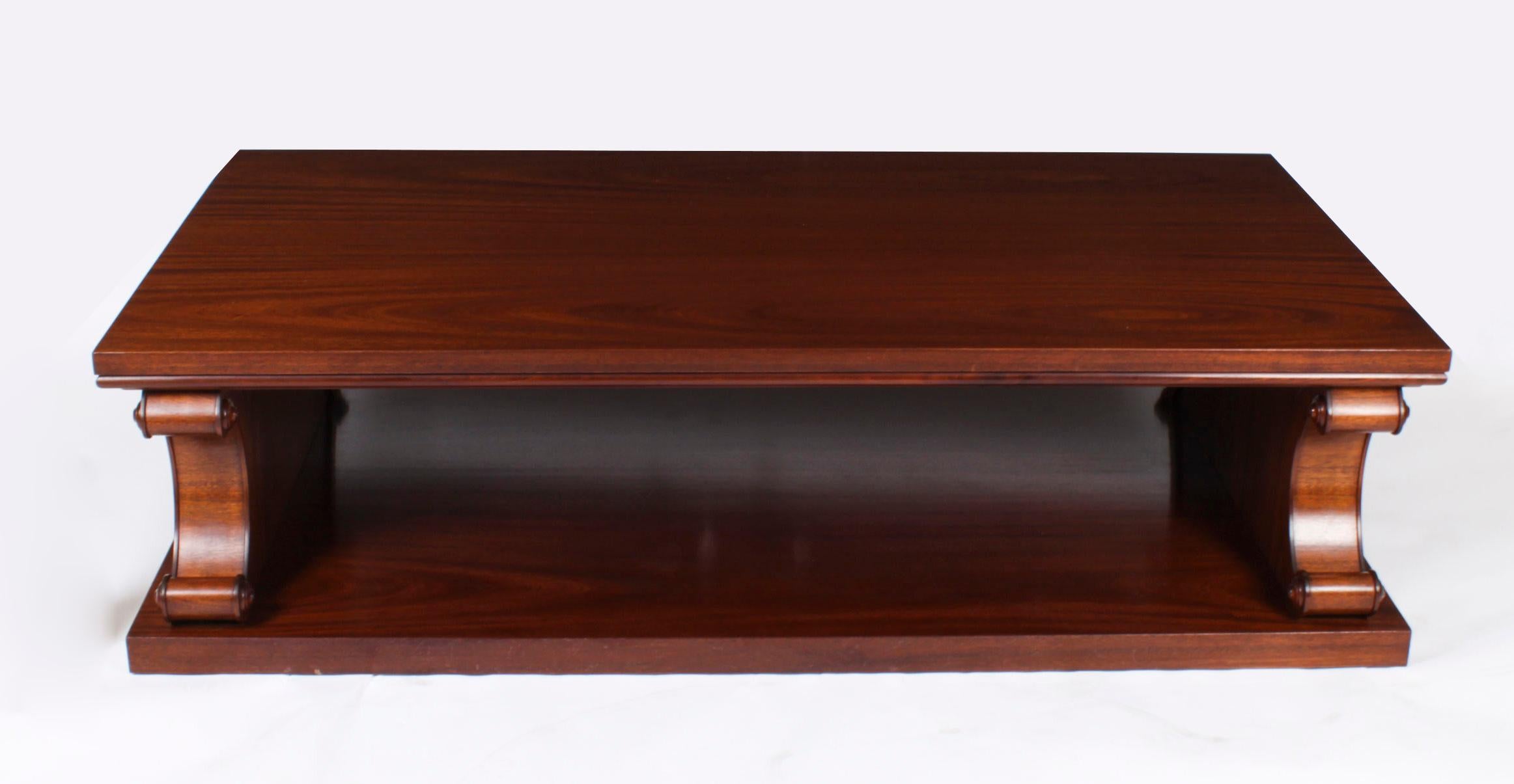 This is a large stunning Regency Revival Vintage mahogany rectangular two tier  coffee table on dual scroll supports, dating from the last quarter of the 20th century.

Provenance:
House on Belgrave Square, London

THE BOTANICAL NAME FOR THE